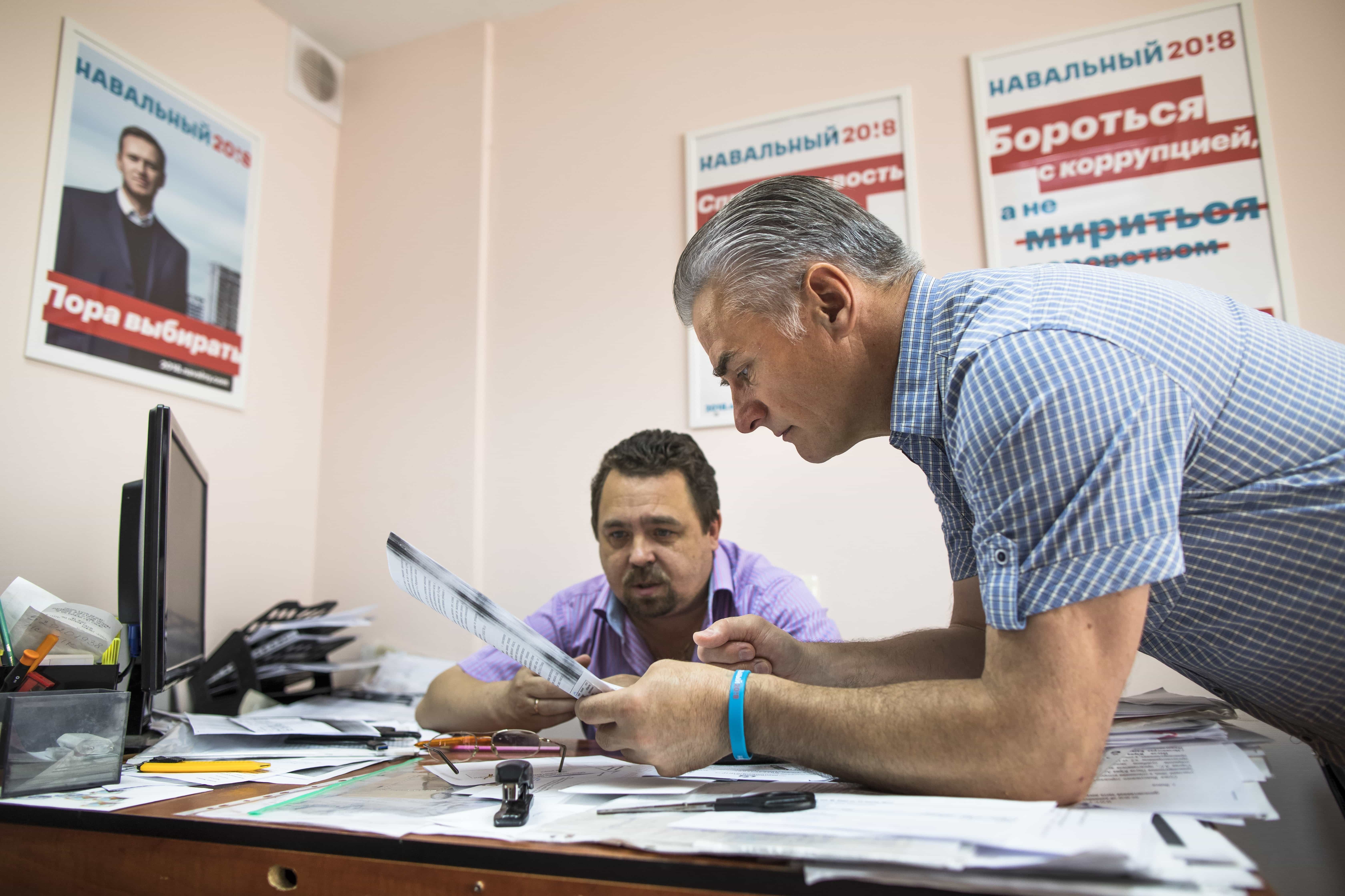 Activists Vyacheslav Burmistrov, right, and Igor Kakonin discuss plans for canvassing at Alexei Navalny's presidential campaign office in Vyksa, Russia, 10 August 2017, AP Photo/Alexander Zemlianichenko