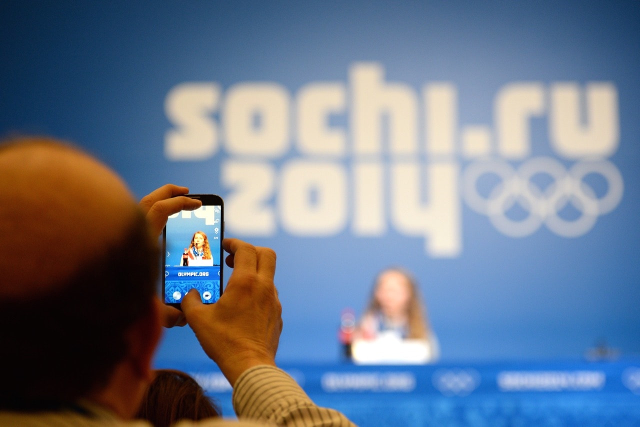 A journalist (L) takes a picture of an American skier at the Main Media Center during the Sochi Winter Olympics in Sochi, Russia, 22 Febuary 2014, JUNG YEON-JE/AFP/Getty Images