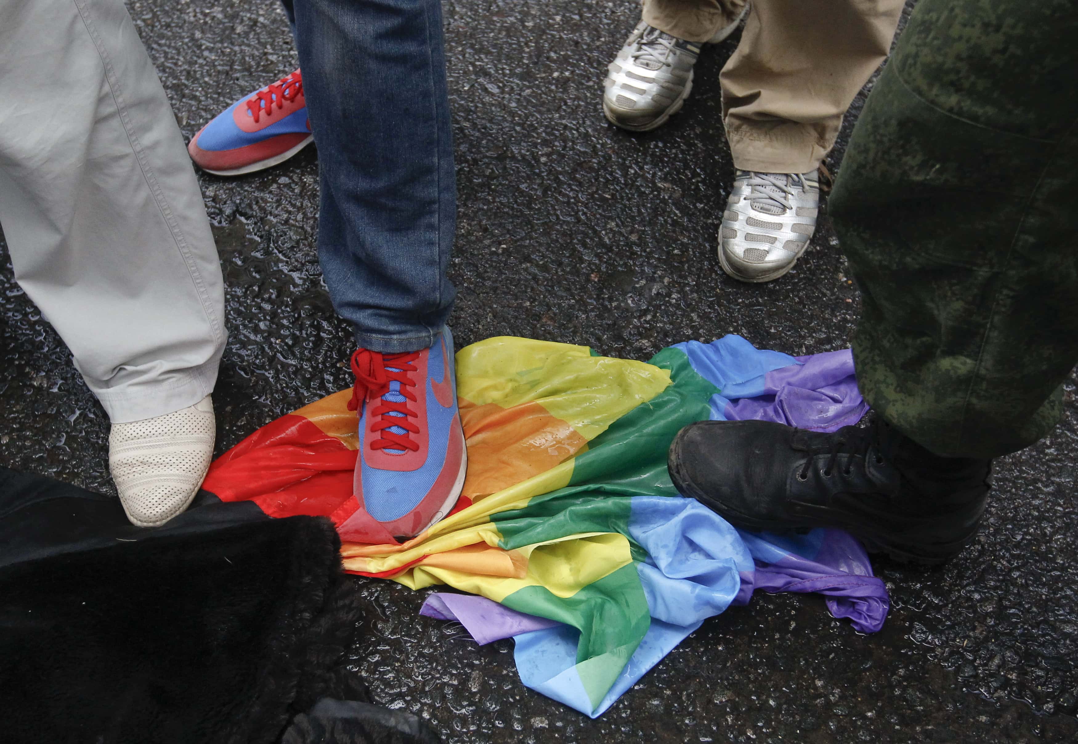 Anti-gay rights activists stand on a rainbow flag during a protest by gay rights activists against the proposed "homosexual propaganda" law, Moscow June 11, 2013., REUTERS/Maxim Shemetov