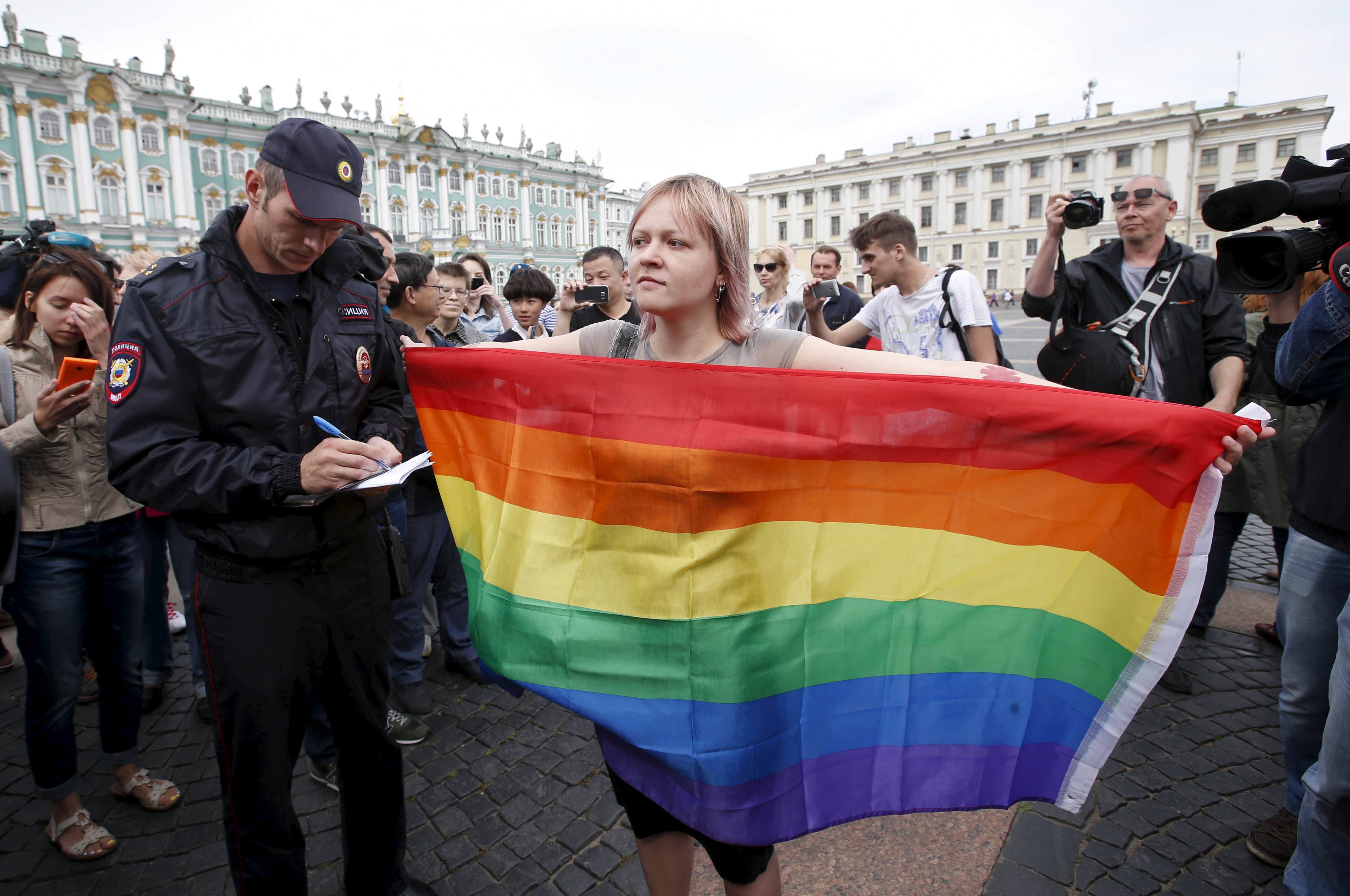 An activist poses with a rainbow flag in front of the media during a protest in Dvortsovaya Square in St. Petersburg, 2 August 2015, REUTERS/Maxim Zmeyev