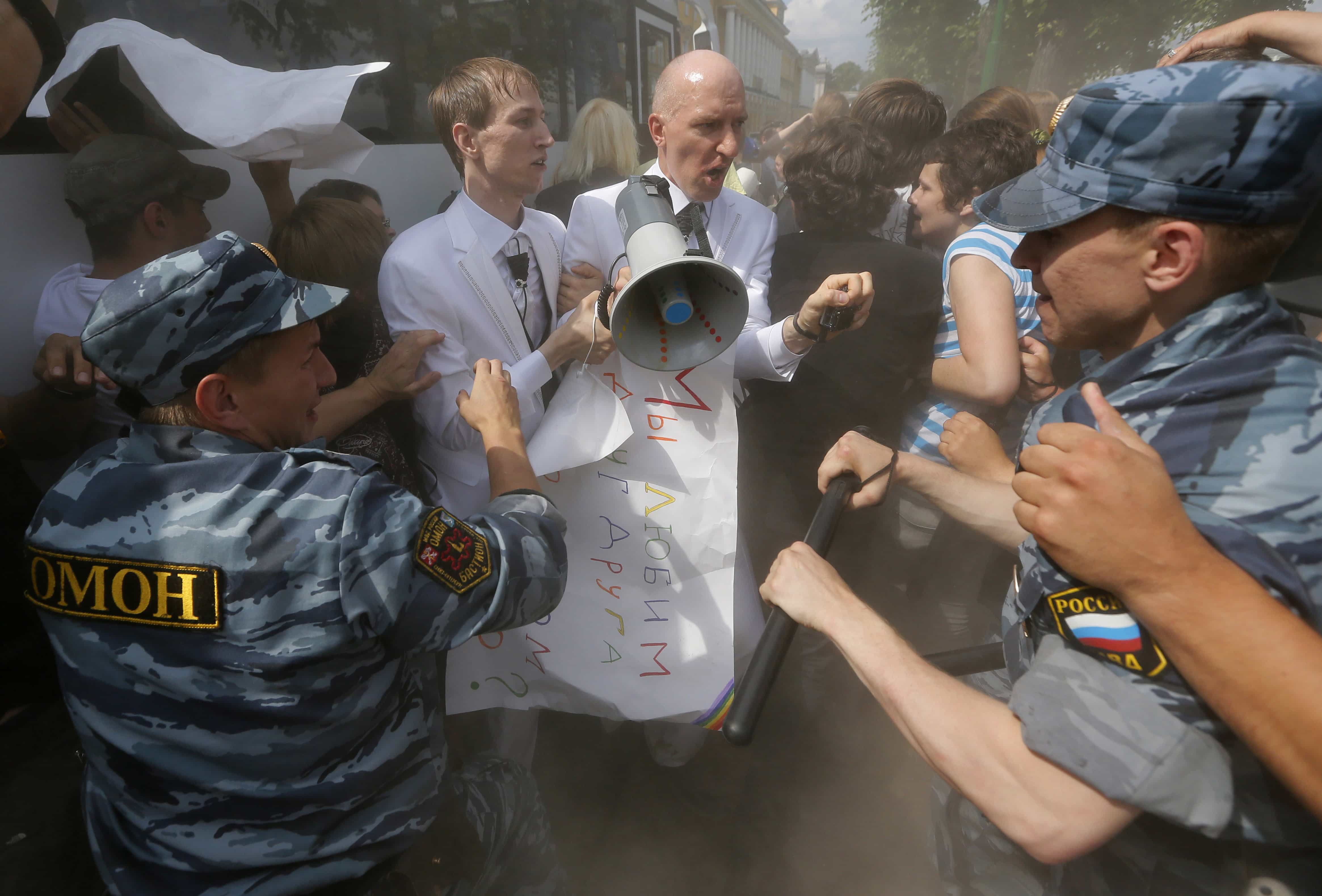 Riot police officers detain gay rights activists Maxim Lysak and Jury Gavrikov during an authorized gay rights rally in St. Petersburg on 29 June 2013. , Dmitry Lovetsky/Associated Press