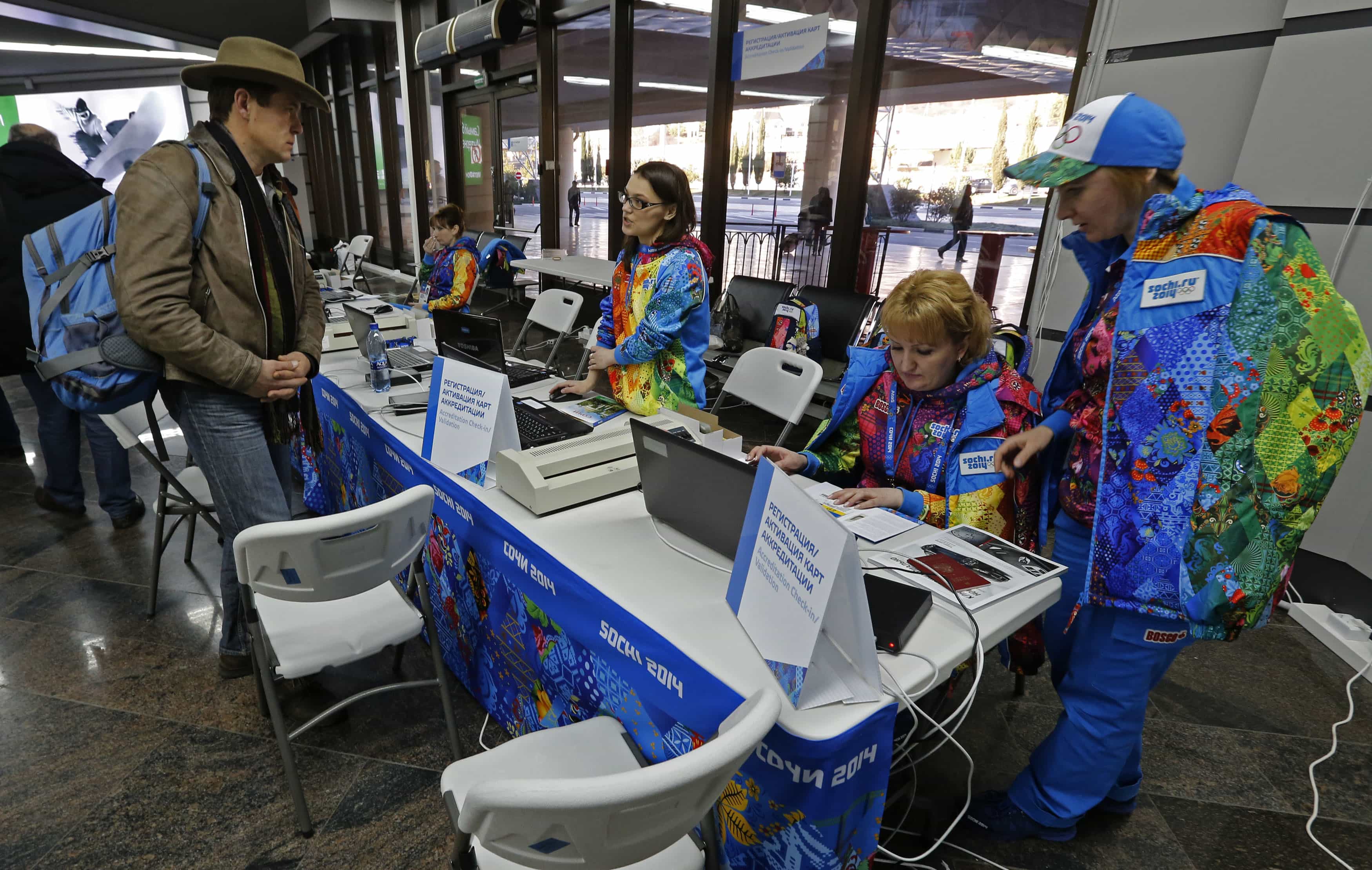 Volunteers assist a journalist with his accreditation for the 2014 Winter Olympics Games in Sochi's airport in Adler, 15 January 2014., REUTERS/Alexander Demianch
