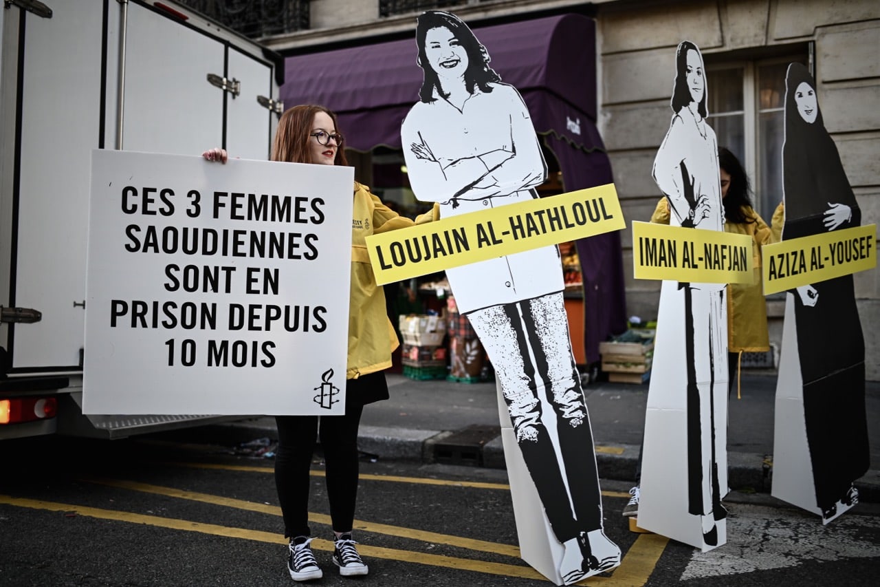 People hold signs and cutouts of women incarcerated in Saudi Arabia during an Amnesty International protest outside the Saudi Arabia embassy in Paris, 8 March 2019, PHILIPPE LOPEZ/AFP/Getty Images