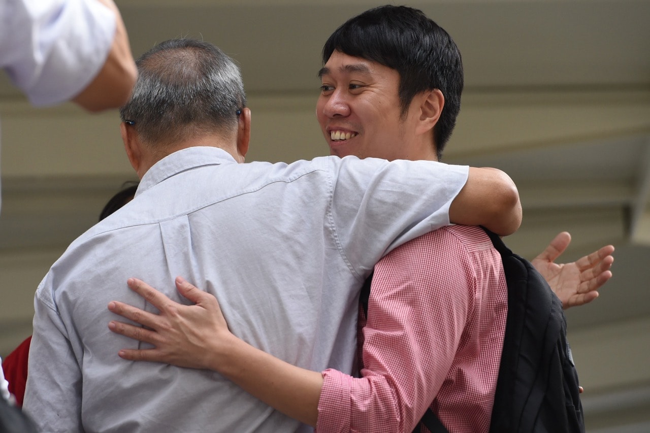 Singaporean human rights activist Jolovan Wham (R) is greeted by friends outside the State Court in Singapore on 29 November 2017, ROSLAN RAHMAN/AFP/Getty Images