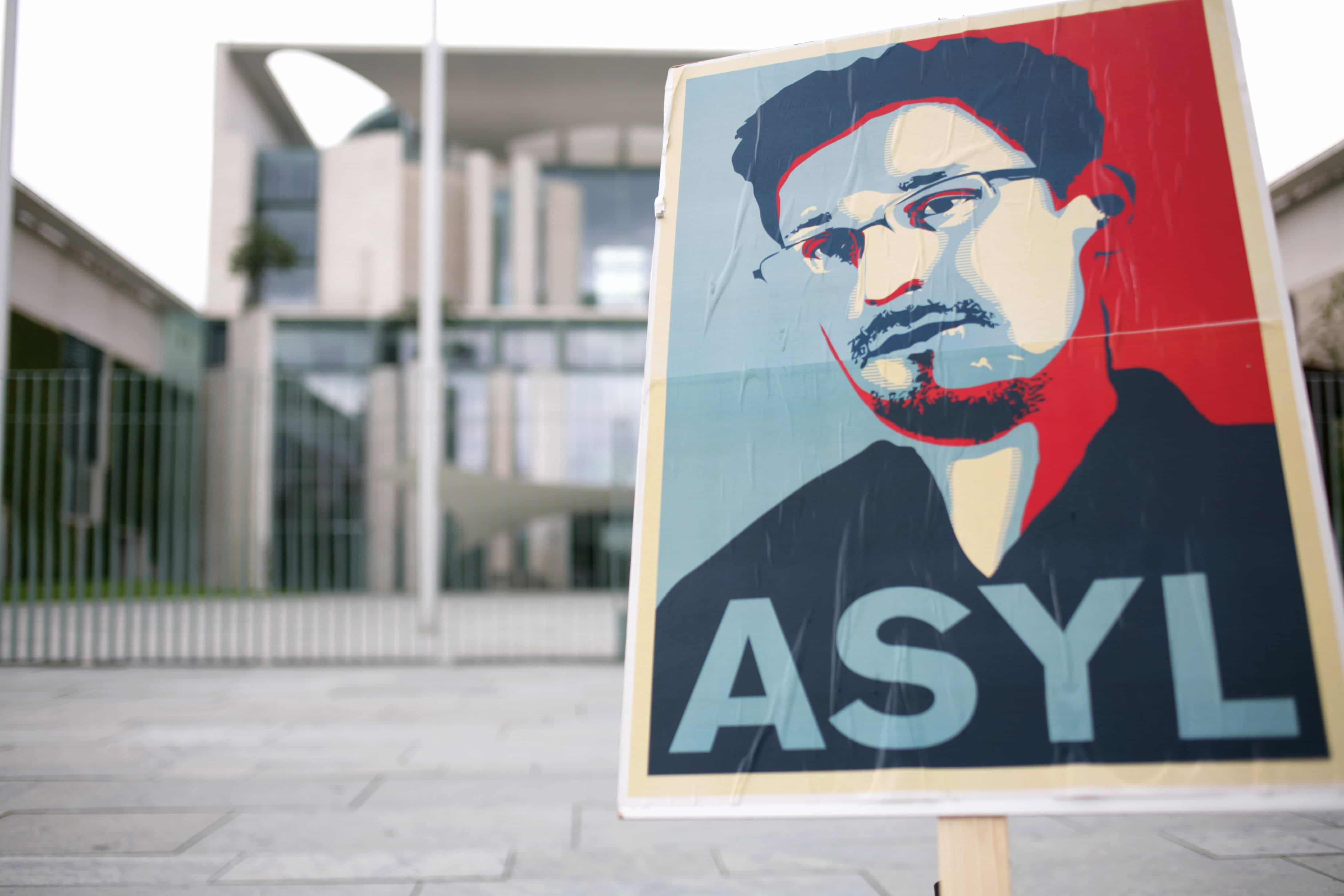 Activists place a placard depicting whistleblower Edward Snowden in front of the German Chancellory in Berlin, 4 July 2013., David von Blohn/NurPhoto/Rex F via AP Images