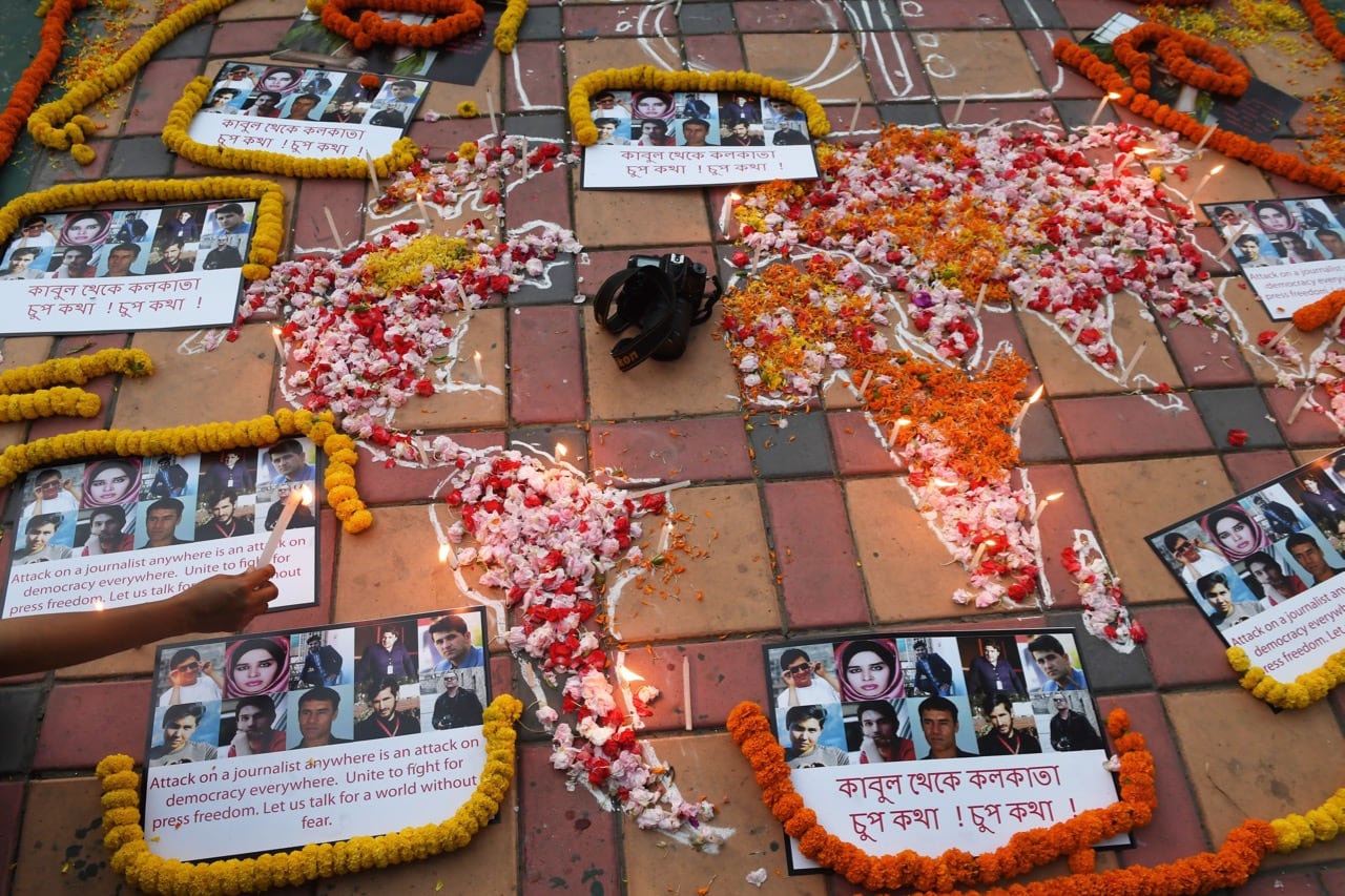 An Indian photojournalist lights a candle during a vigil for ten Afghan journalists who were killed in a targeted suicide bombing and on the eve of World Press Freedom Day in Kolkata, 2 May 2018, DIBYANGSHU SARKAR/AFP/Getty Images