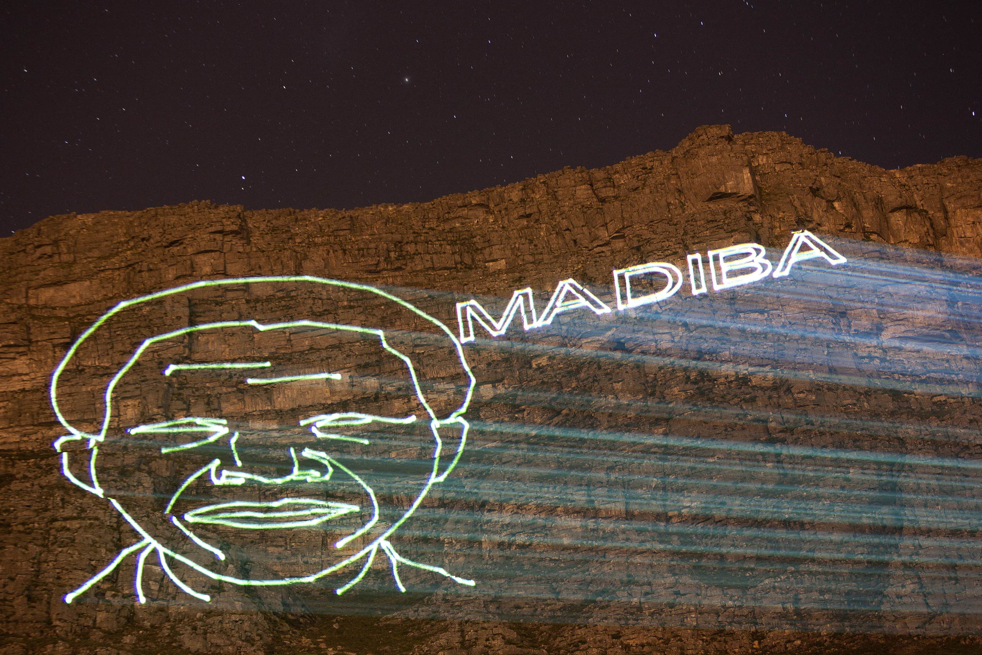 A projection of the face of former South African President Nelson Mandela and his clan name Madiba is projected onto the face of Table Mountain in Cape Town, 8 December 2013. , REUTERS/Mark Wessels