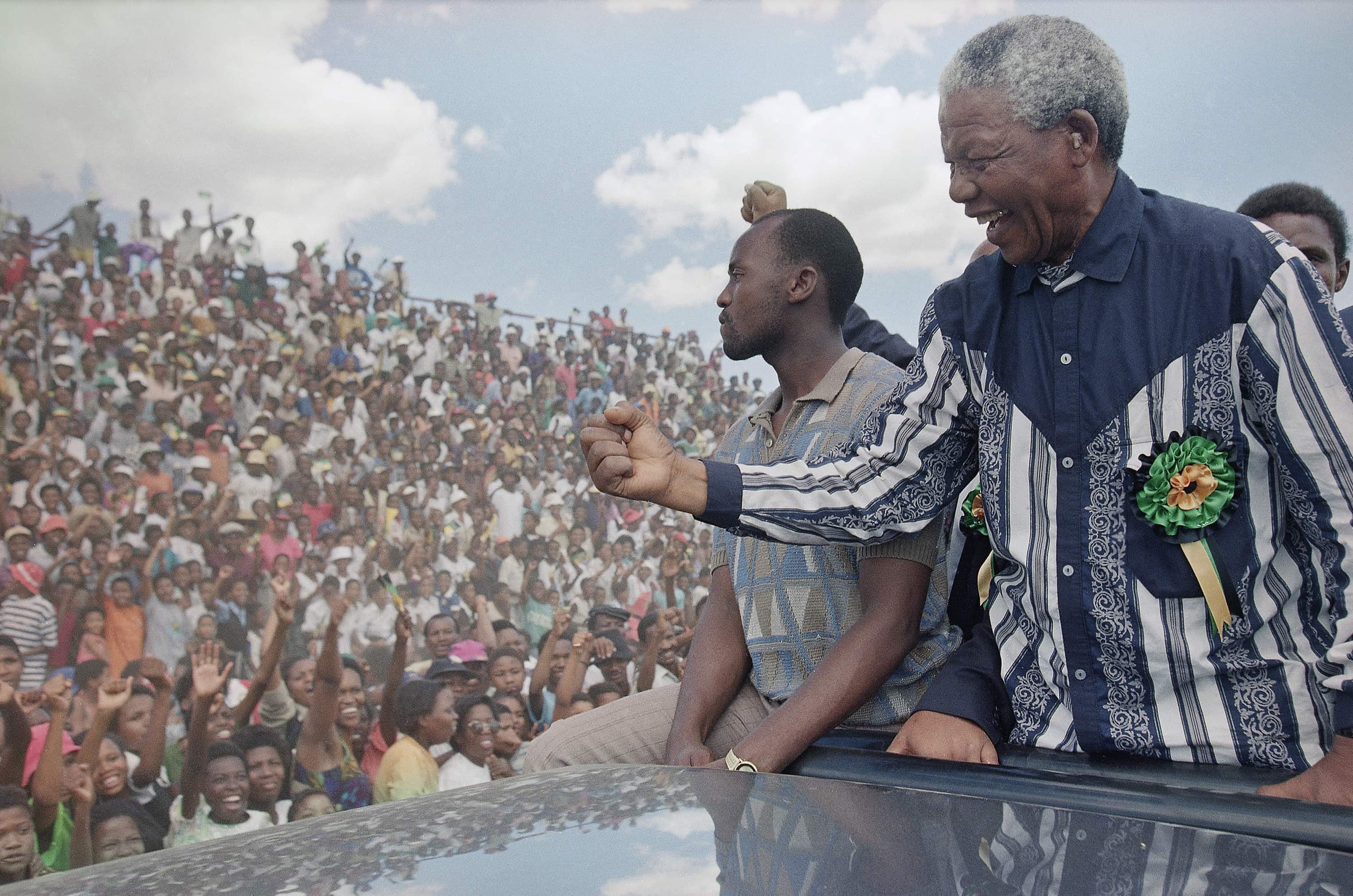 Nelson Mandela salutes the crowd in Galeshewe Stadium near Kimberley, South Africa, before a "People's Forum" on 25 February 1994. , AP Photo/David Brauchli