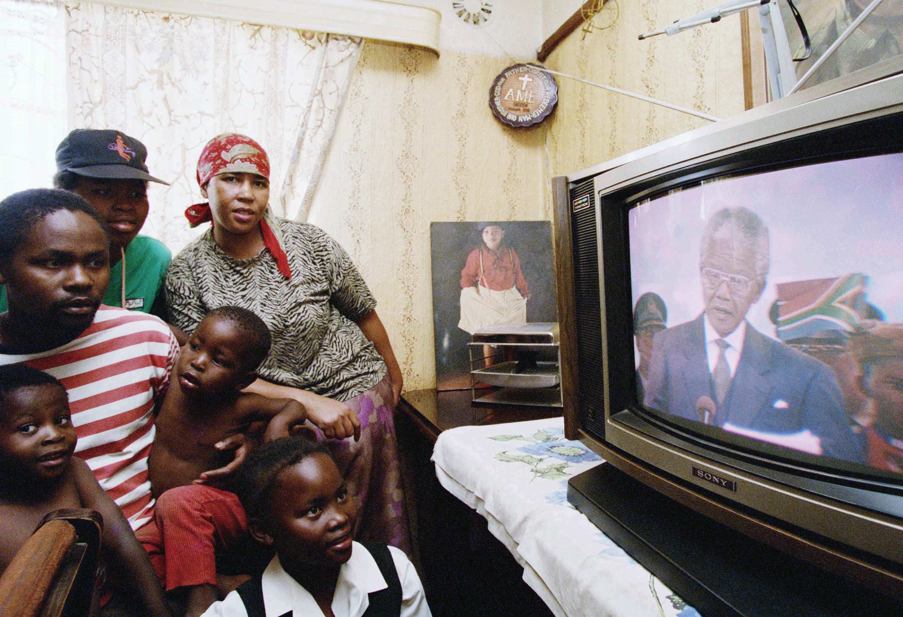 Members of the Moledi family in Soweto, South Africa watch a live broadcast of the inauguration of President-elect Nelson Mandela in Pretoria, May 10, 1994., AP Photo/Joao Silva