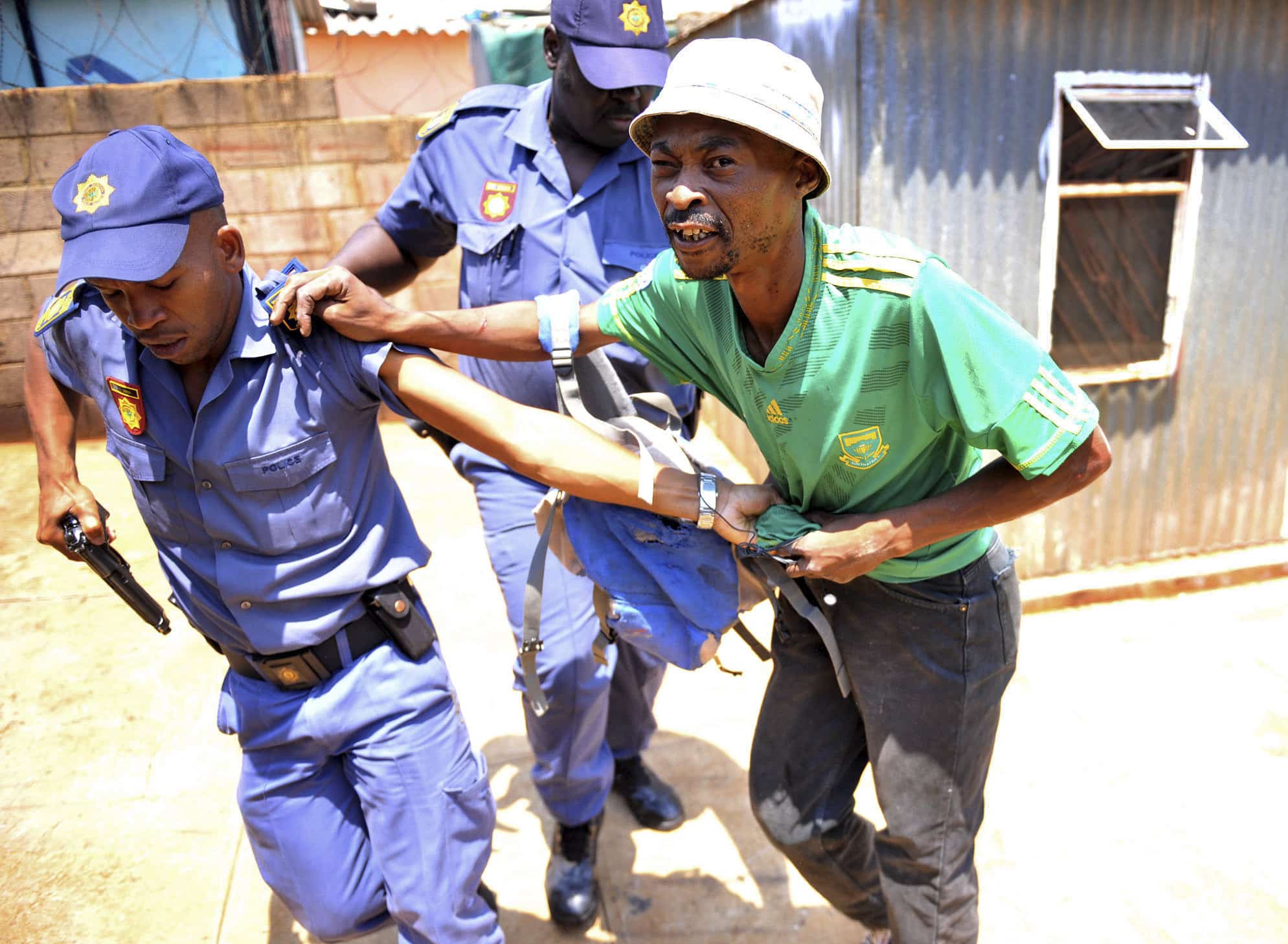 In this photo taken on 22 January 2015, police arrest a man suspected of looting a store in Soweto, South Africa., AP Photo