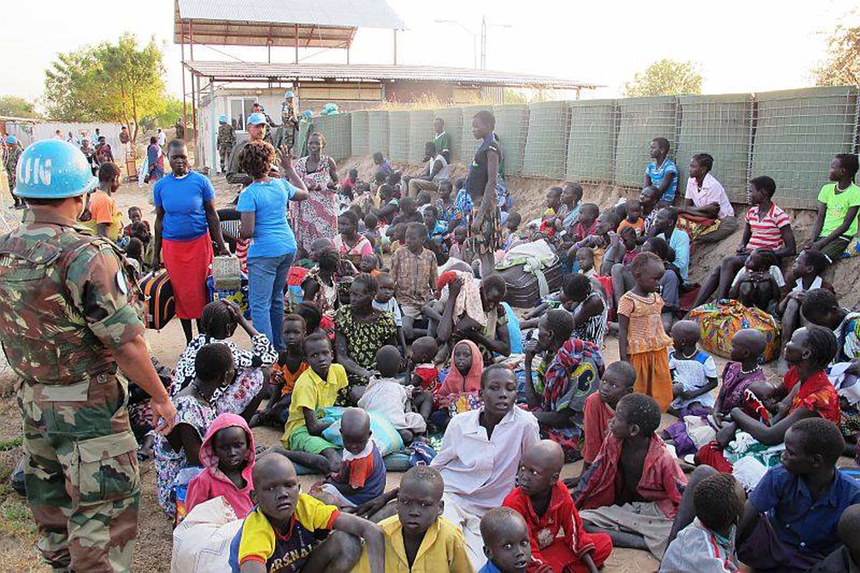 A United Nation soldier stands guard as civilians arrive at the UNMISS compound adjacent to Juba International Airport to take refuge on 17 December 2013., AP Photo/UNMISS/Rolla Hinedi