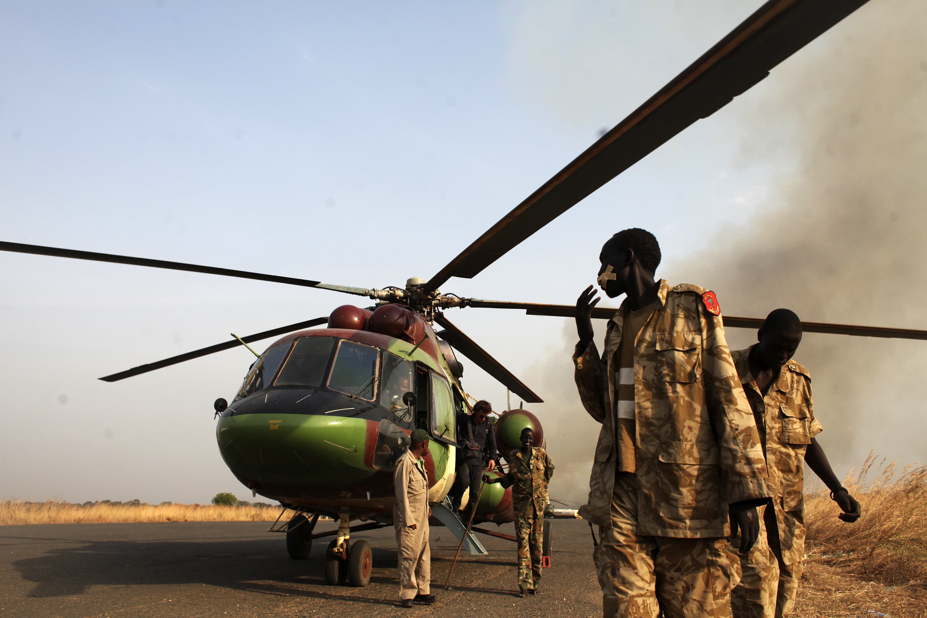 SPLA soldiers and a journalist leave a helicopter after a flight to Bor, in Juba, South Sudan January 25, 2014, REUTERS/Andreea Campeanu