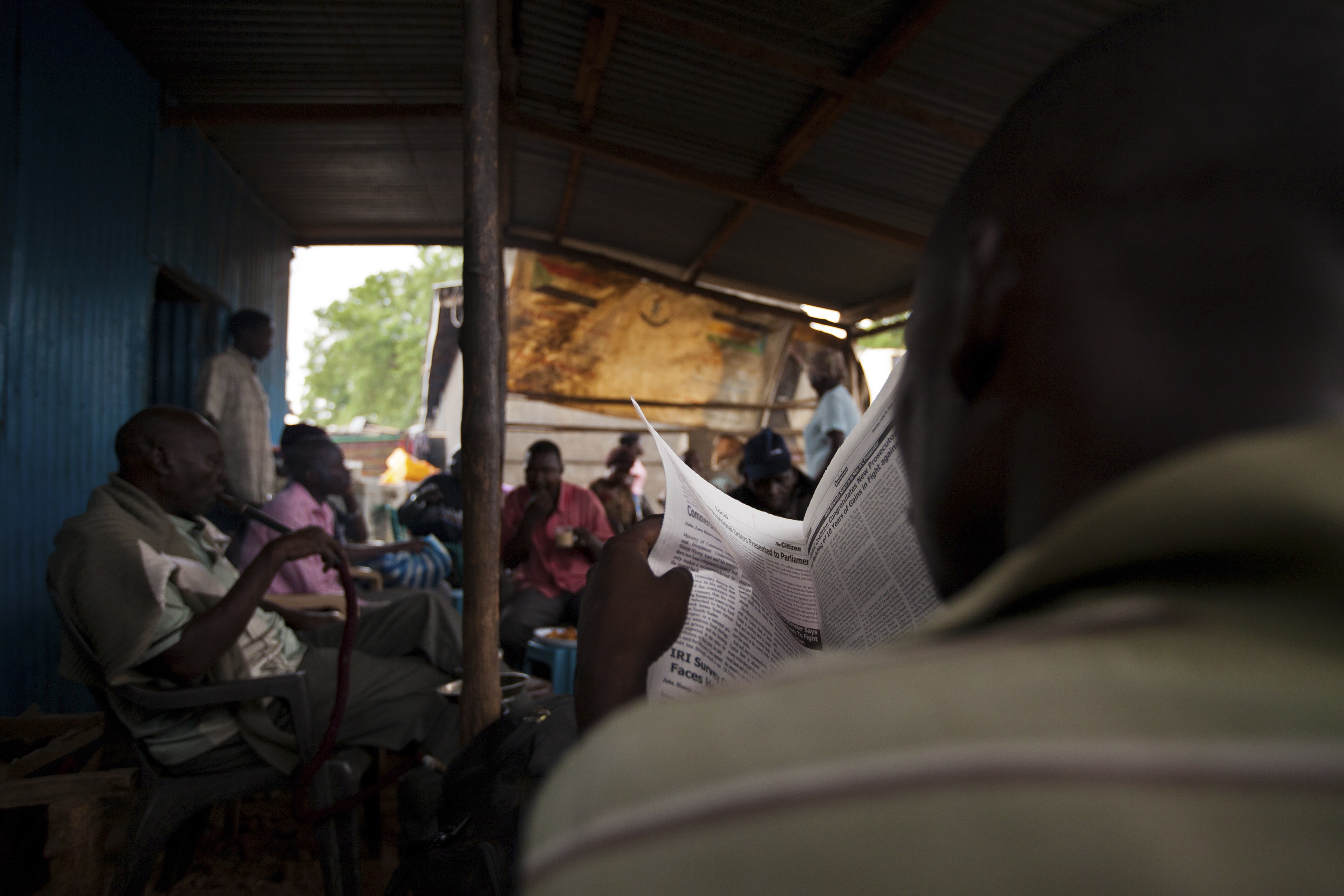 A newspaper vendor is photographed reading in Juba, South Sudan, 18 June 2012, REUTERS/Adriane Ohanesian