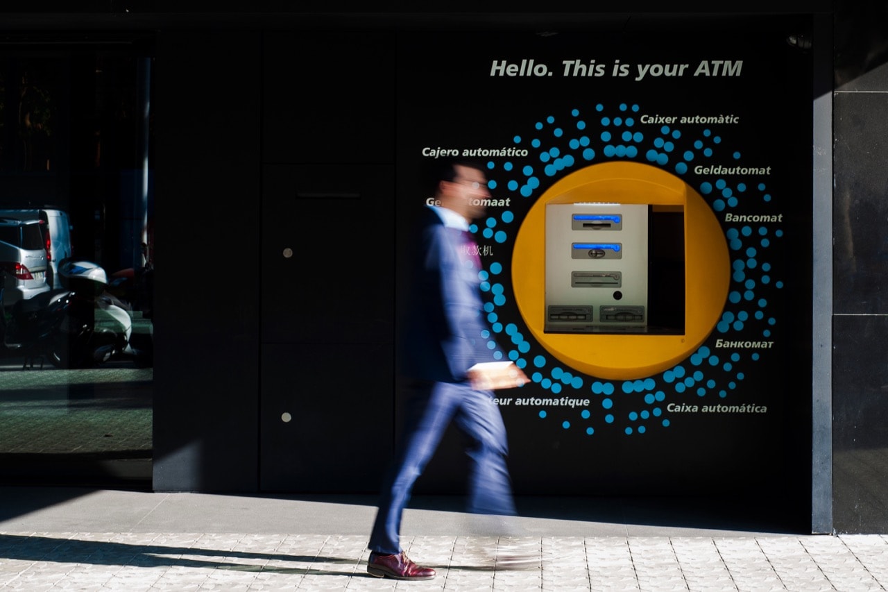 A man walking by an ATM, in Barcelona, Spain, 17 May 2017, Joan Cros Garcia/Corbis via Getty Images