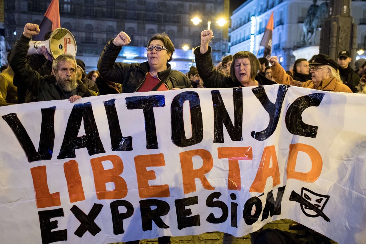People protesting with a sign that reads "freedom of expression" after rapper Valtonyc was convicted for the lyrics of his songs, in Madrid, Spain, 23 February 2018, Marcos del Mazo/LightRocket via Getty Images
