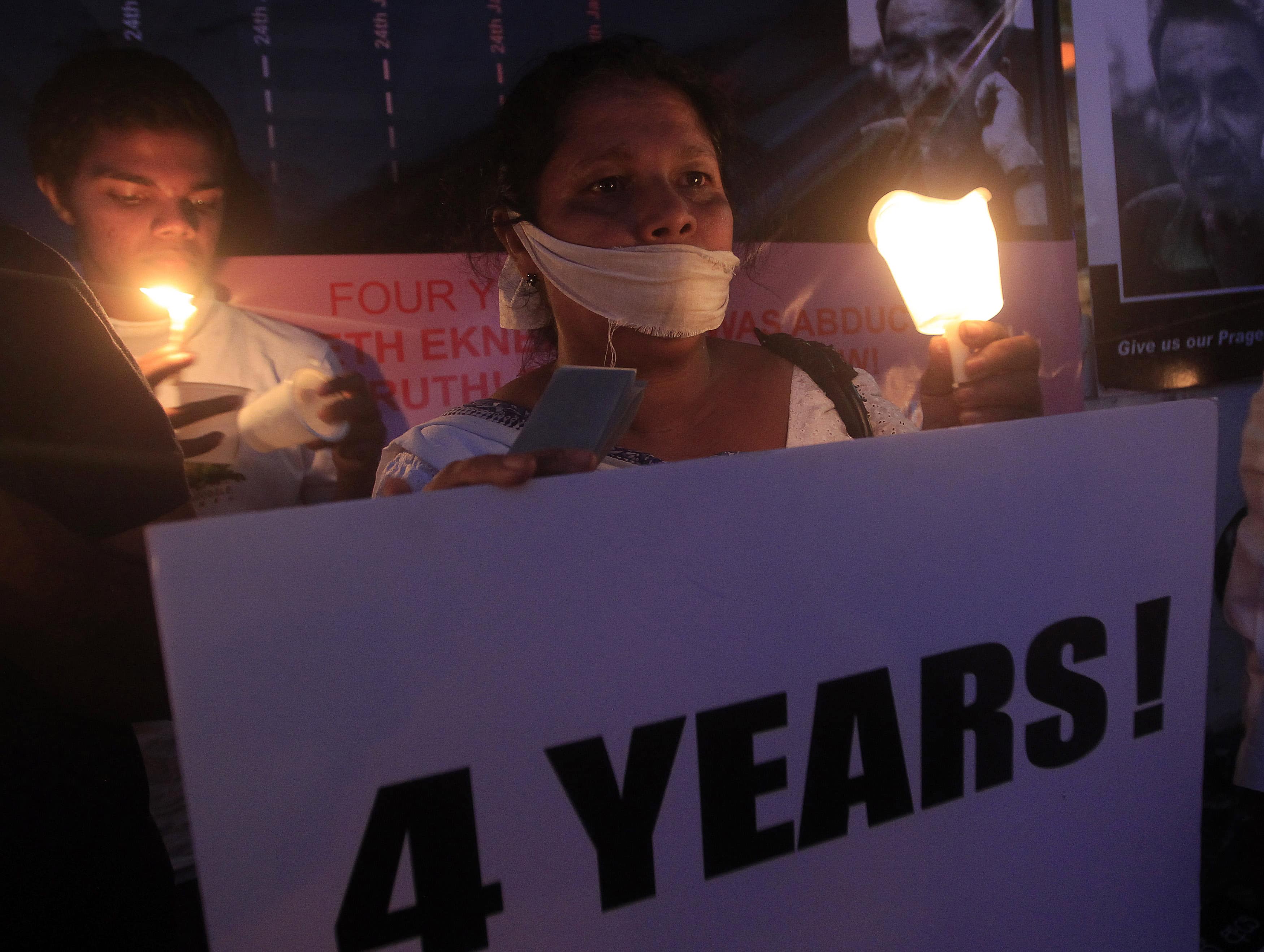 Sandhya Eknaligoda, wife of missing cartoonist and columnist Prageeth Eknaligoda, holds a candle at a vigil for her husband in Colombo, 24 January 2014, REUTERS/Dinuka Liyanawatte