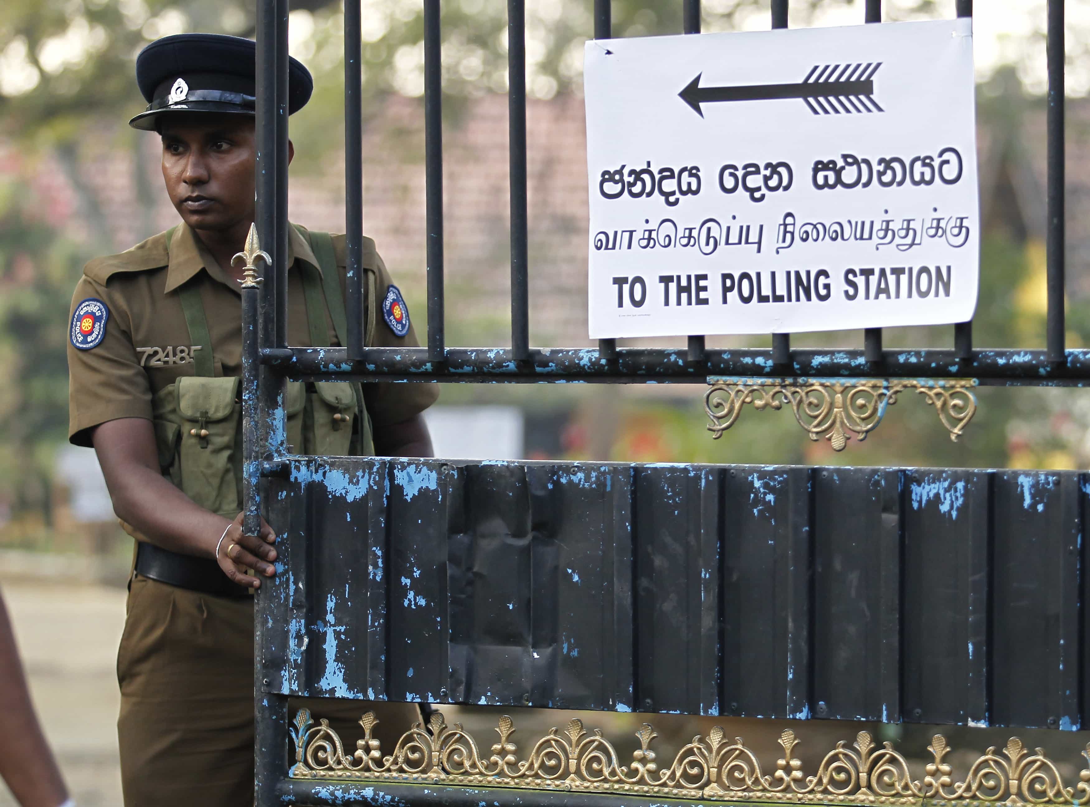 A police officer stands guard at a polling station for the presidential election, in Medamulana, 8 January 2015, REUTERS/Dinuka Liyanawatte