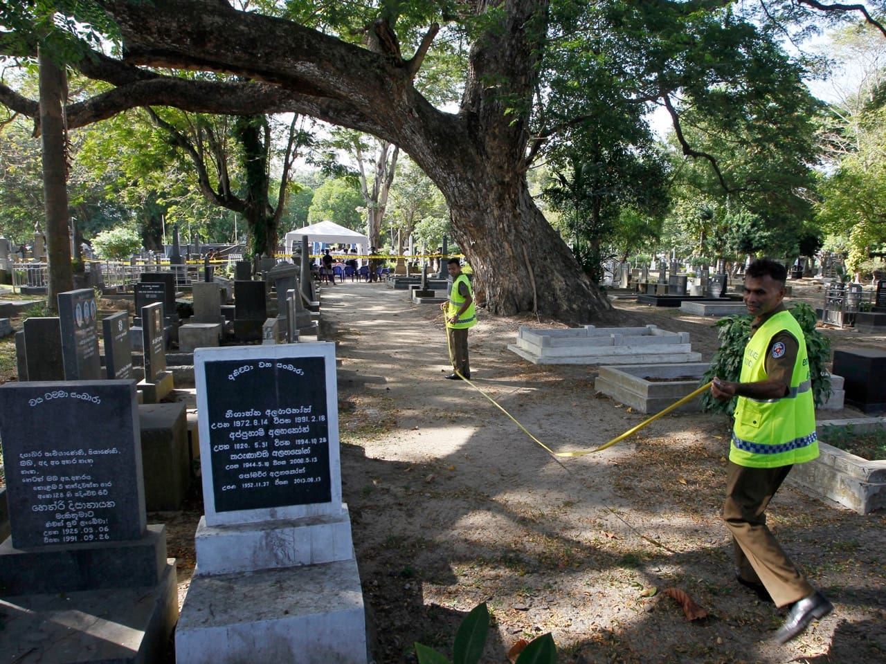 Sri Lankan crime investigating police officers prepare to exhume the remains of editor Lasantha Wickrematunge at a cemetery in Colombo, 27 September 2016, AP Photo/Eranga Jayawardena