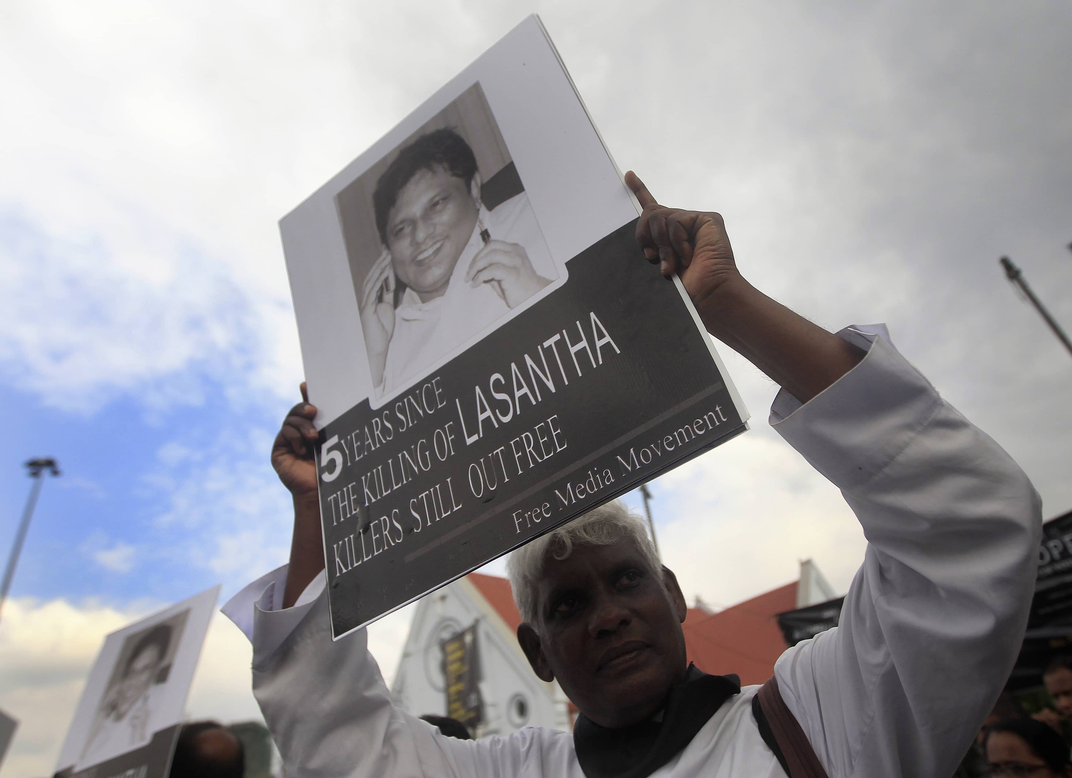 A Catholic priest holds up an image of journalist Lasantha Wickrematunge during a protest in Colombo, 28 January 2014, REUTERS/Dinuka Liyanawatte