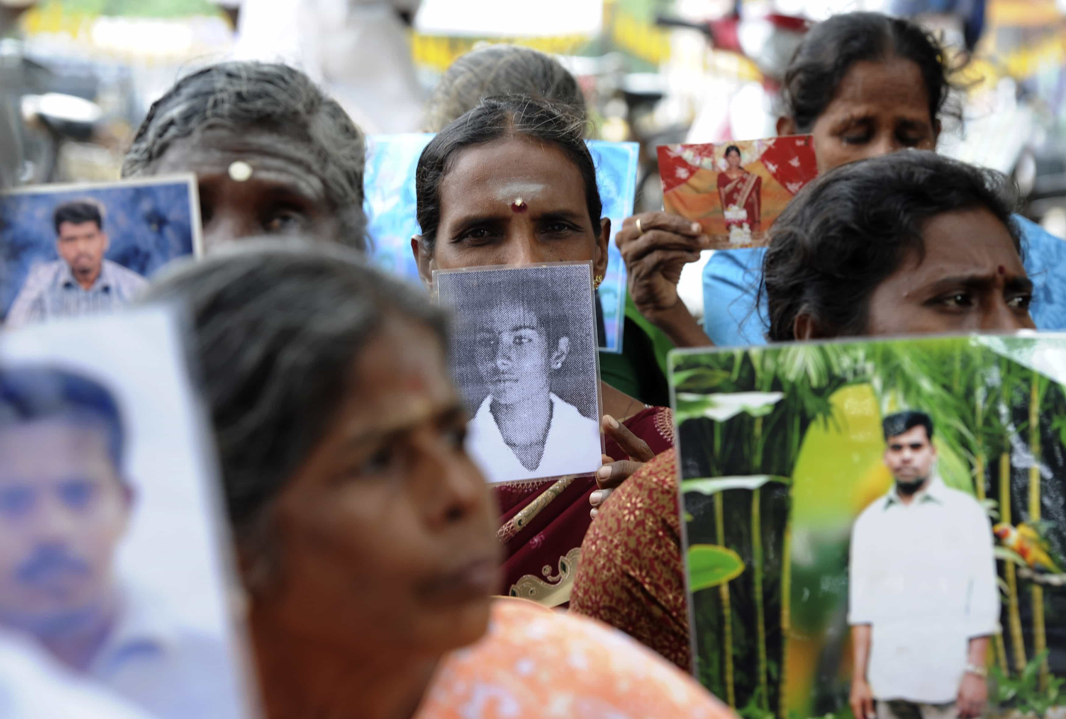 Sri Lankan Tamils hold pictures of family members who disappeared during the war against the Liberation Tigers of Tamil Eelam (LTTE) at a protest in Jaffna, 15 November 2013, REUTERS/Stringer