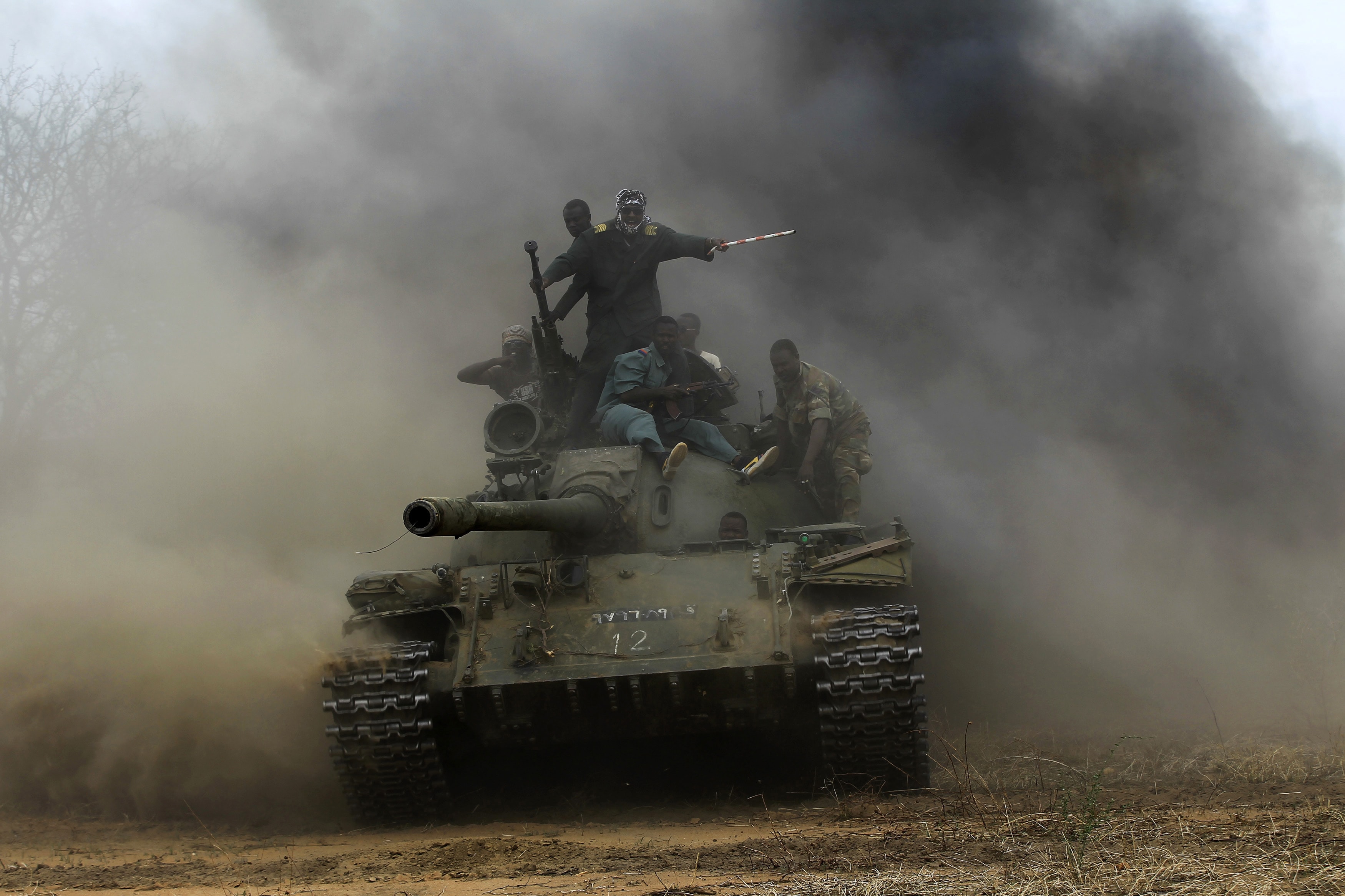 Sudanese Armed Forces and Rapid Support Forces (RSF) personnel ride on a tank after recapturing the Daldako area, 20 May 2014., REUTERS/Mohamed Nureldin Abdallah