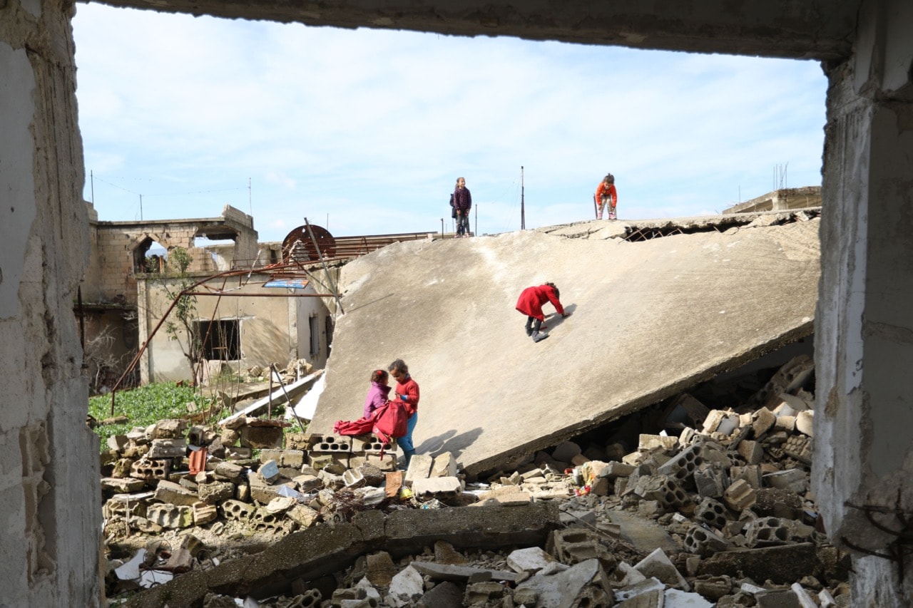 Children play outside their destroyed school in Frikeh village, Idlib province, Syria, 18 February 2018, OMAR HAJ KADOUR/AFP/Getty Images