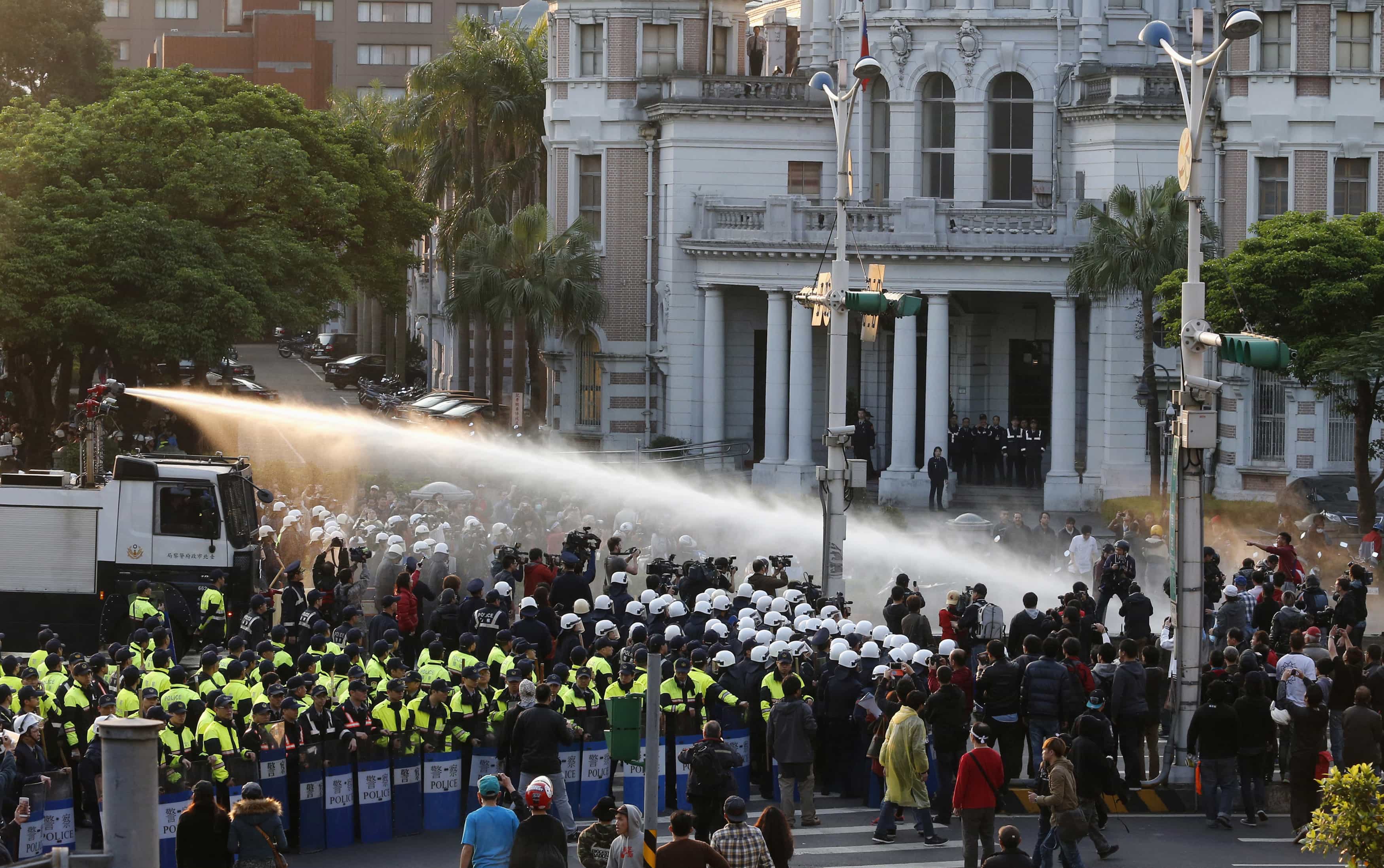 Police use water cannons to disperse demonstrators as they protest against a trade pact with mainland China, near Taiwan's government headquarters in Taipei, 24 March 2014, REUTERS/Edward Lau