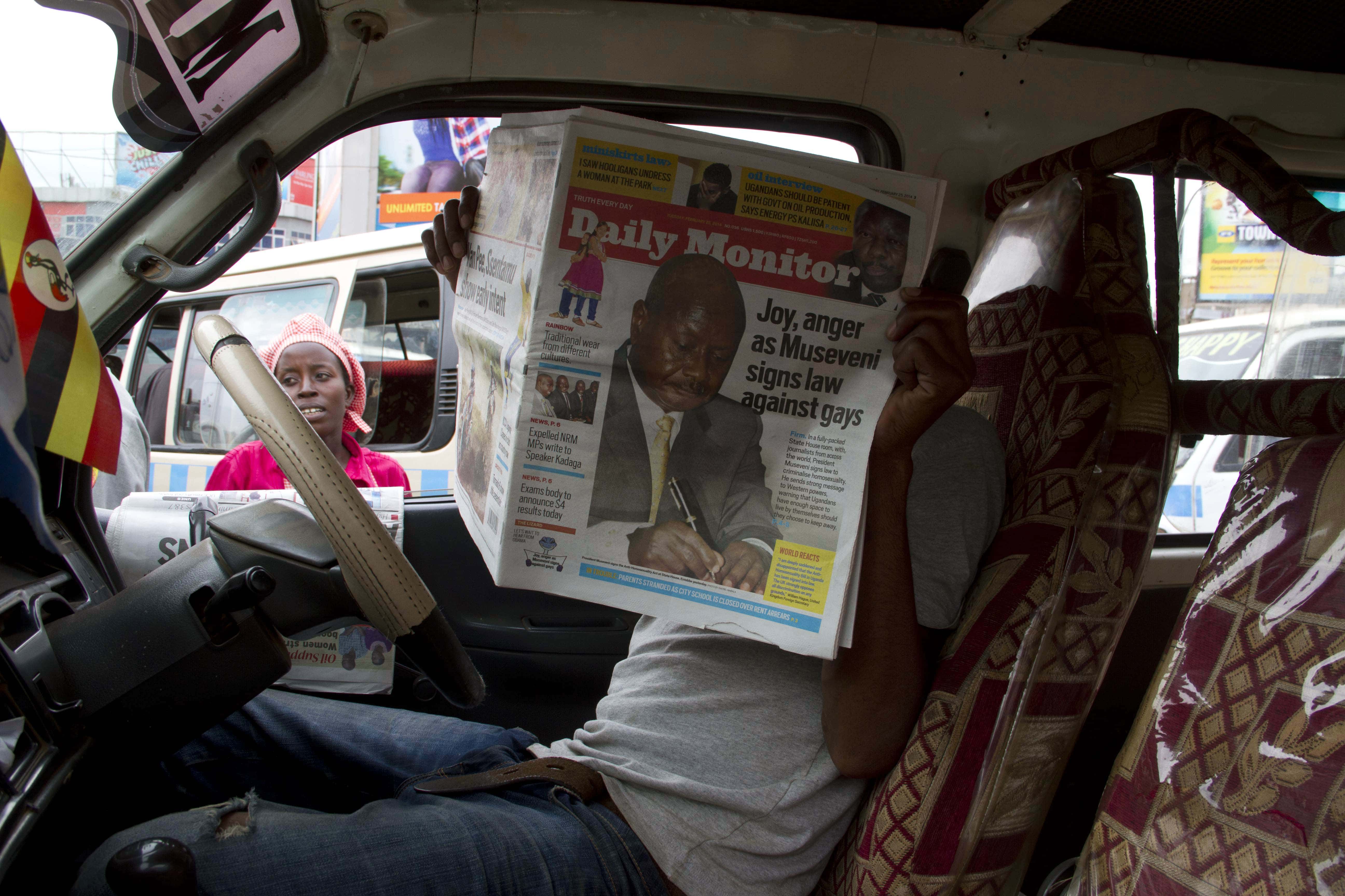 A taxi driver reads Ugandan newspaper, the Daily Monitor. Simon Emwamu from the paper and two other reporters were arrested for unlawful assembly while covering protest in the country's Eastern region, Uganda, 2014,  ISAAC KASAMANI/AFP/Getty Images