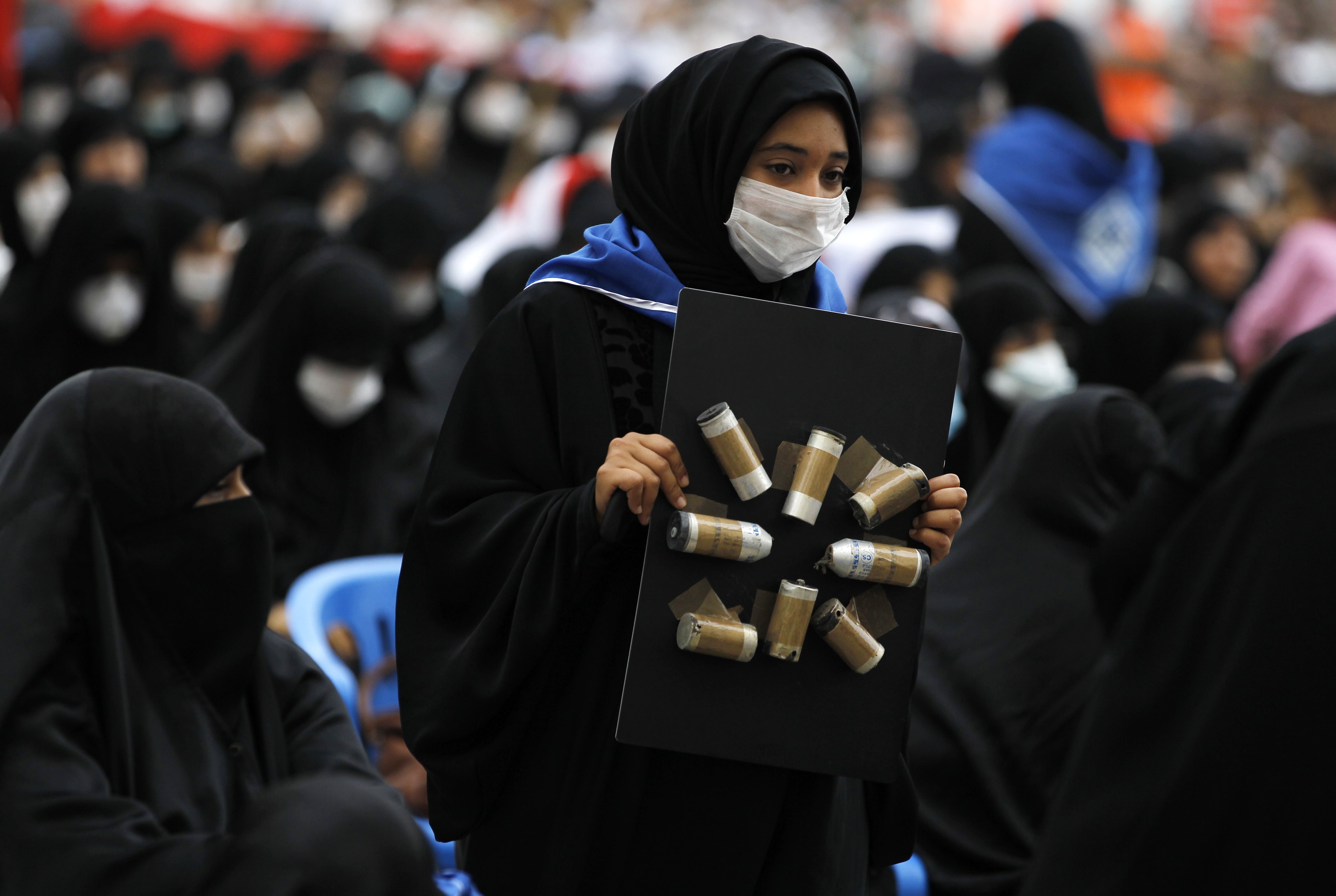 An anti-government protester holds a board with used teargas canisters taped on it, during a demonstration in Manama on 29 March 2012 to condemn the heavy use of teargas in Bahrain, REUTERS/Hamad I Mohammed