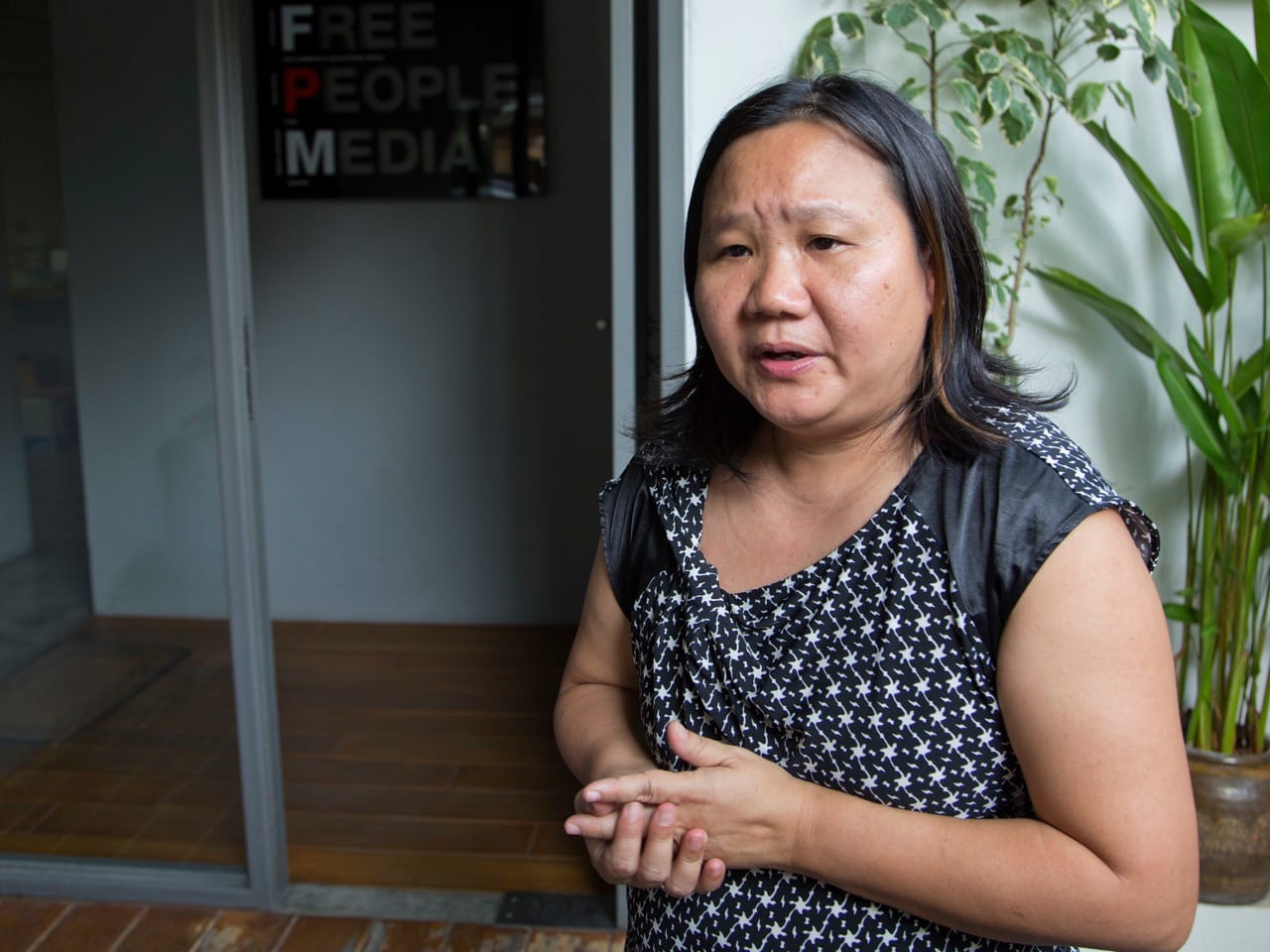 Chiranuch Premchaiporn, director of the independent news website Prachatai, talks to the media outside her offices following a visit by Thai police in Bangkok, 12 July 2016, AP Photo/Mark Baker