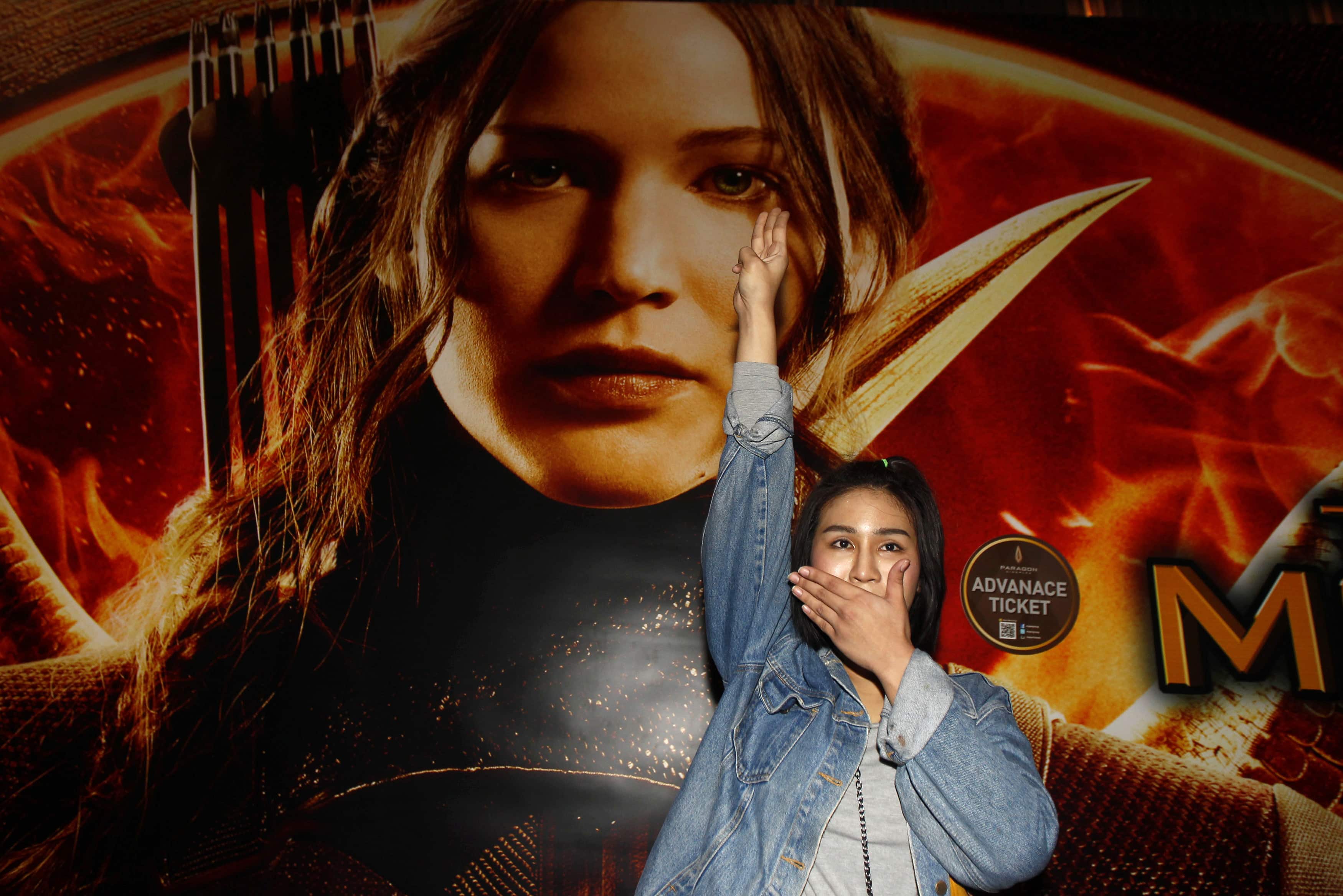 A student flashes a three-finger salute inspired by the movie "The Hunger Games" outside the Siam Paragon cinema in Bangkok, 20 November 2014, REUTERS/Chaiwat Subprasom