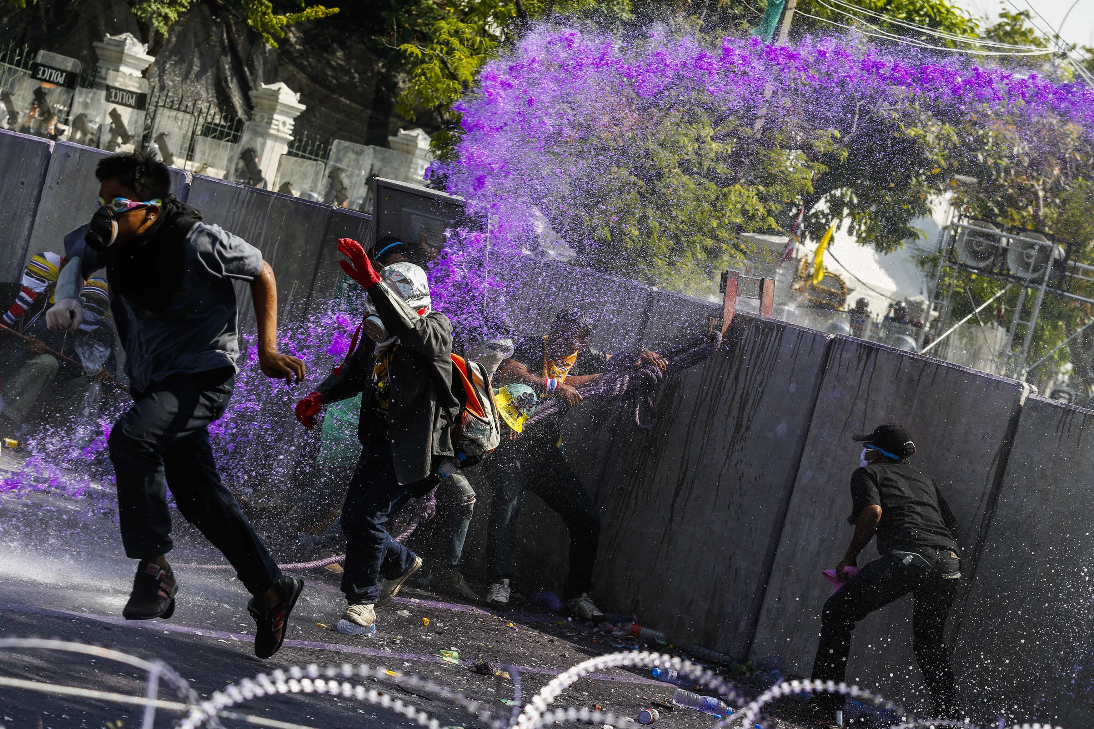 Anti-government protesters flee as riot policemen use a water cannon during clashes near the metropolitan police headquarters in Bangkok, 2 December 2013, REUTERS/Athit Perawongmetha