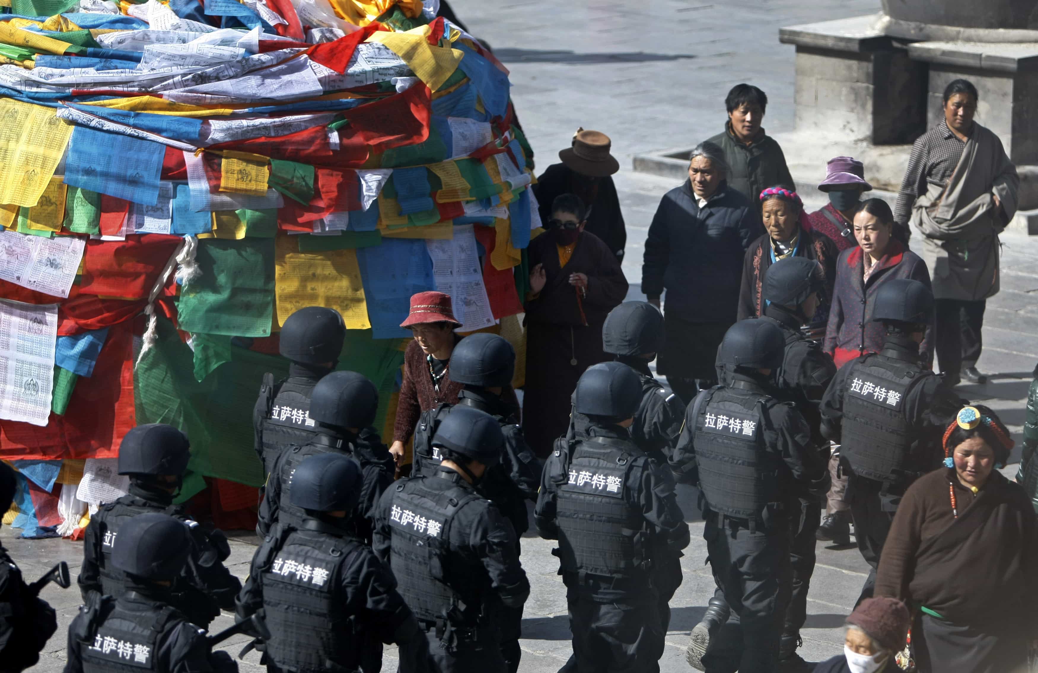 Policemen from the Special Weapons and Tactics (SWAT) team patrol on a street outside Jokhang Monastery in Lhasa, 14 March 2014, REUTERS/Jacky Chen