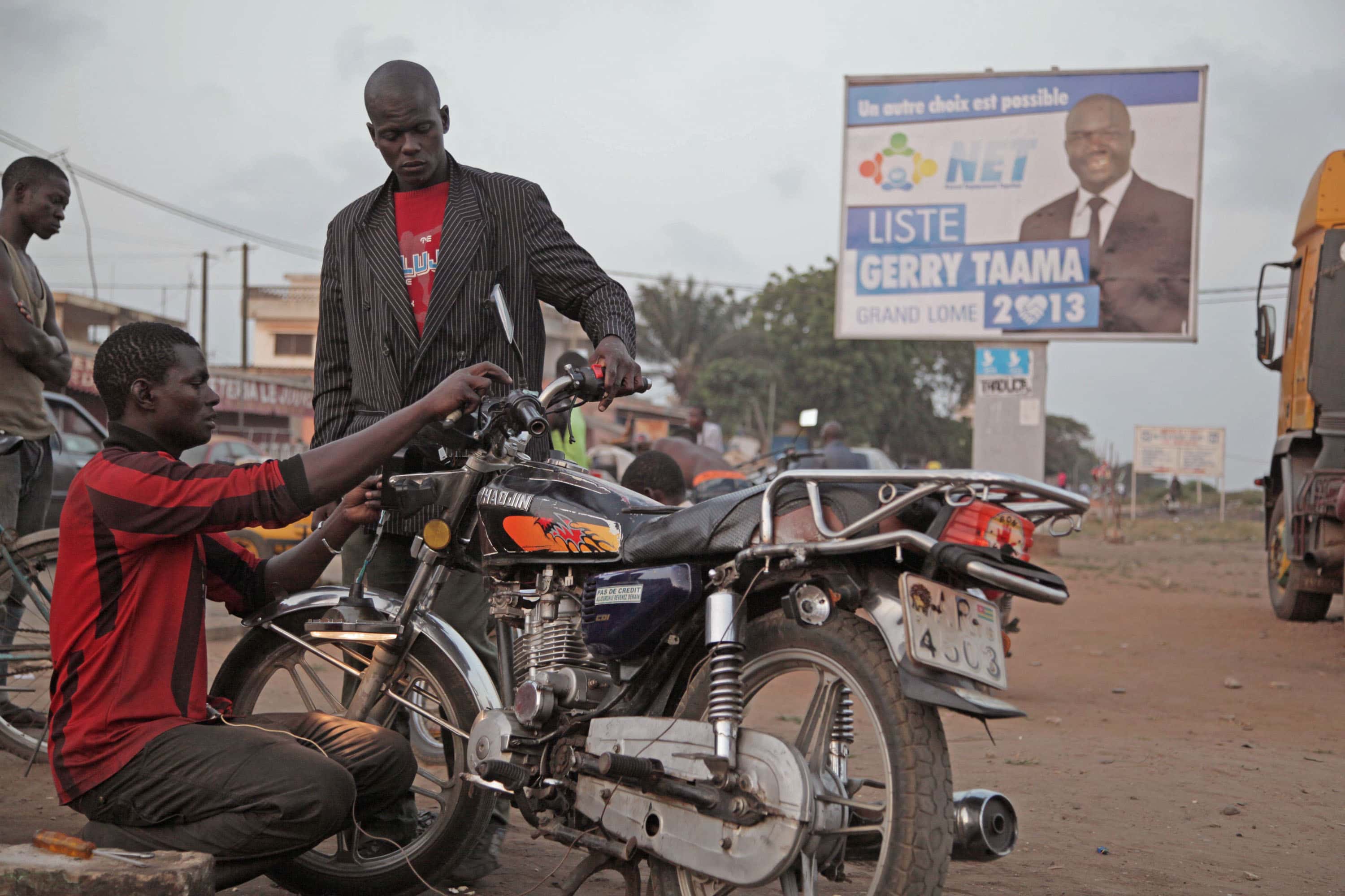 Men work on a motorcycle in Lomé, Togo, on 17 July 2013, AP Photo/Erick Kaglan