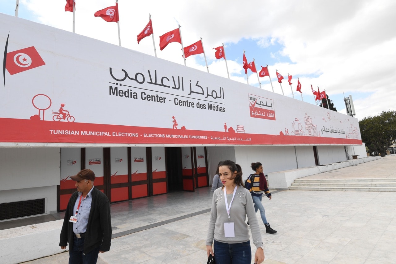 Journalists and media center staff walk outside the elections press center in the capital Tunis, 4 May 2018, FETHI BELAID/AFP/Getty Images