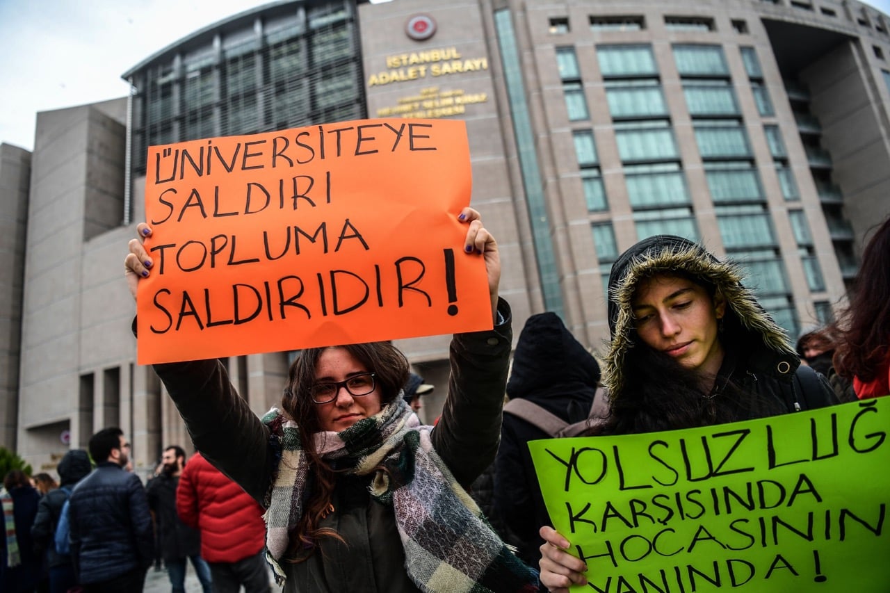 Protesters hold placards reading "An attack towards a University is an attack towards the community - Against corruption, we are with our Academics", during a demonstration in front of a courthouse in Istanbul, Turkey, 5 December 2017, OZAN KOSE/AFP/Getty Images