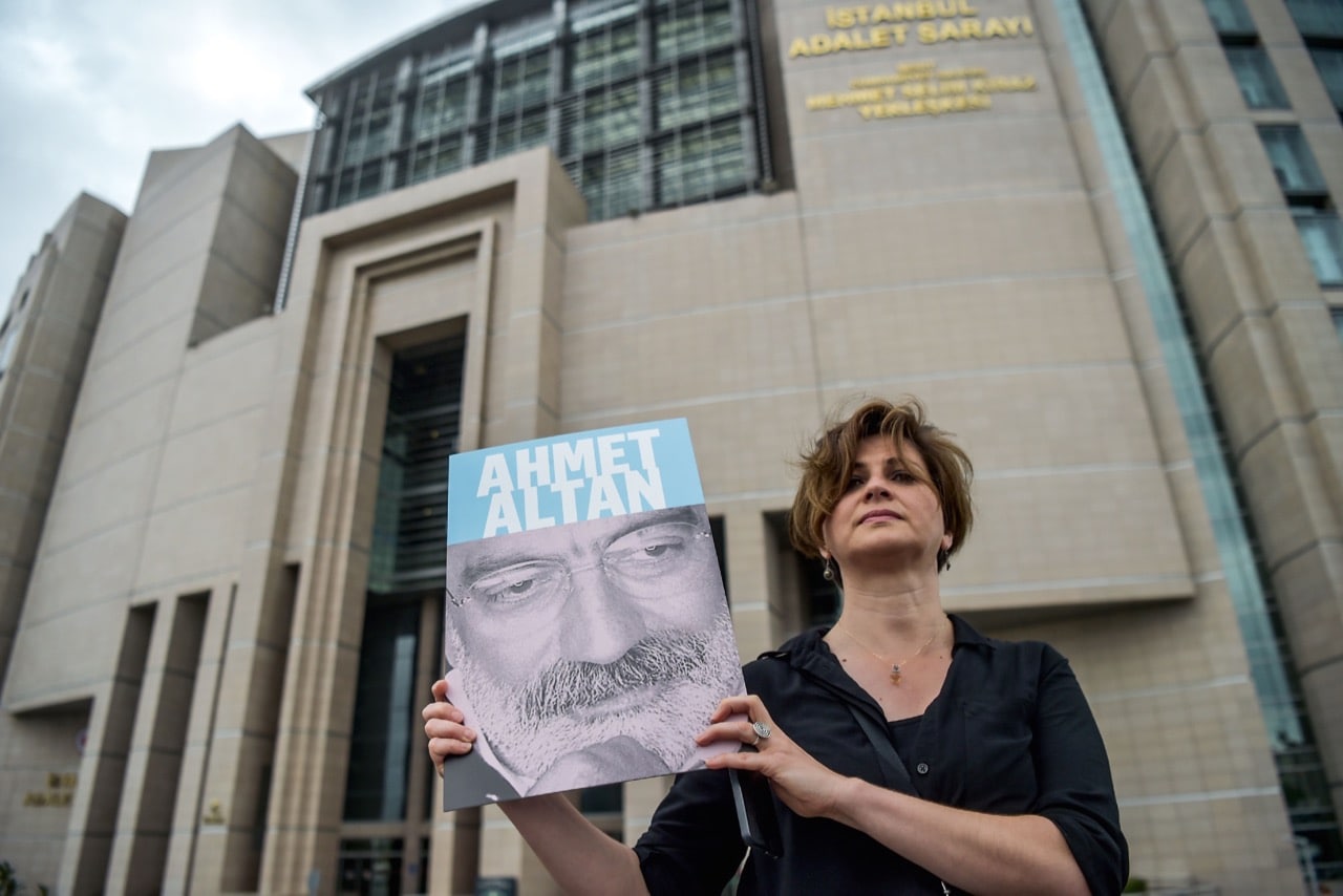 A journalist poses with a portrait of Turkish journalist Ahmet Altan on 19 June 2017 in front of the Istanbul courthouse, where his trial was to take place , OZAN KOSE/AFP/Getty Images