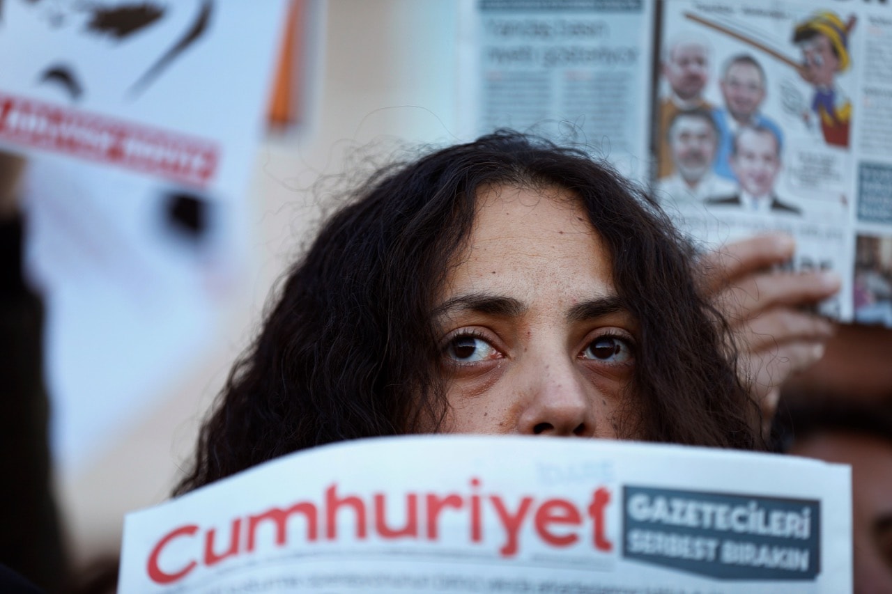 A demonstrator holds a copy of "Cumhuriyet" newspaper during a protest outside a court in Istanbul, 31 October 2017, AP Photo/Lefteris Pitarakis
