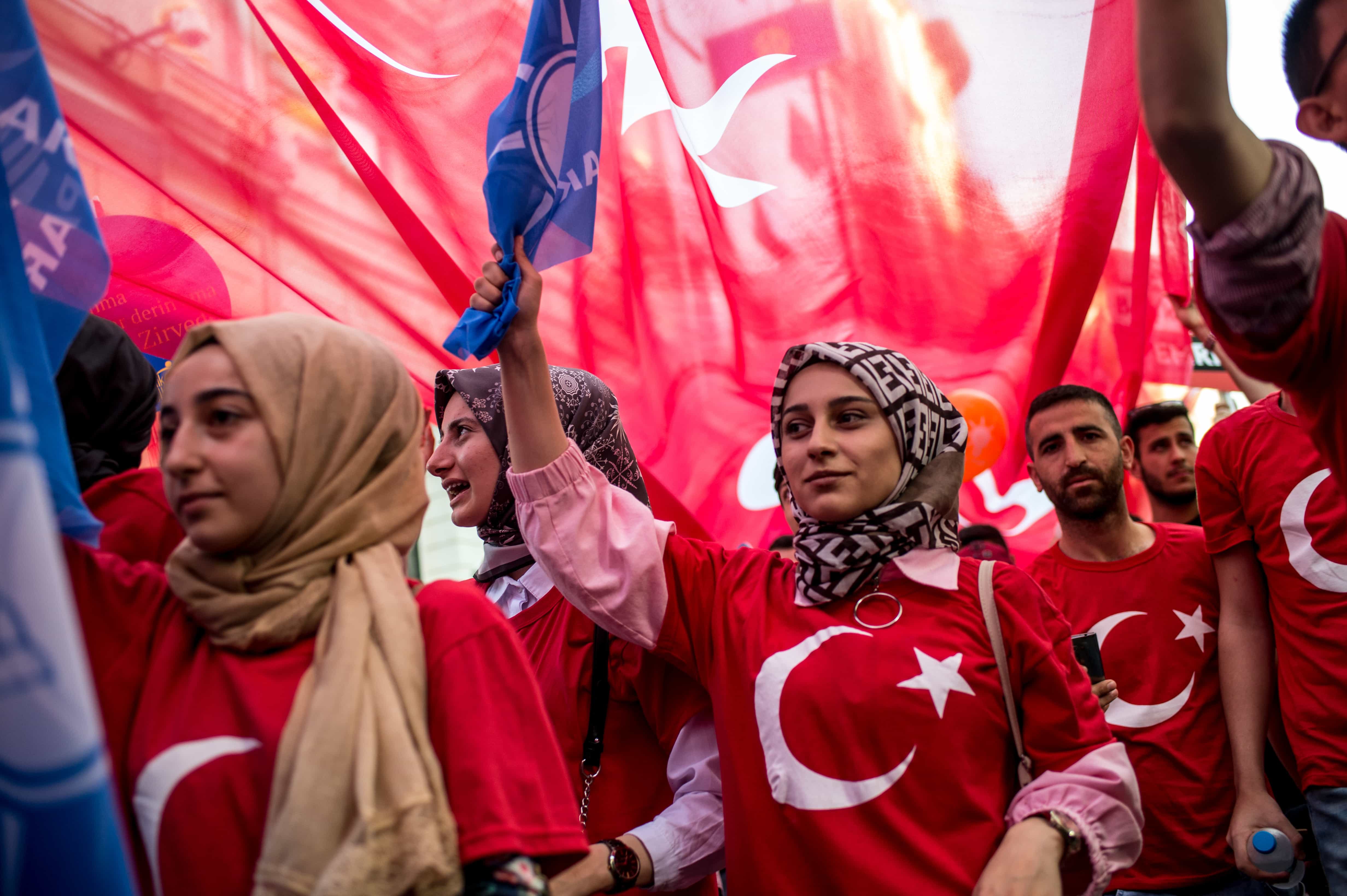 Supporters of the Turklish president wear T-shirts in the design of the national flag and carry a large flag during an election campaign rally for the AK Party in Istanbul, 20 June 2018, YASIN AKGUL/AFP/Getty Images