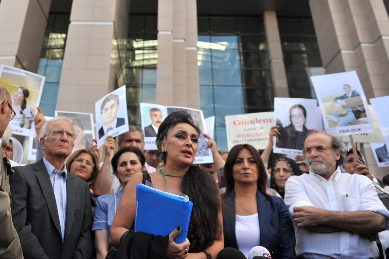 Eren Keskin (C), director of "Özgür Gündem" newspaper, speaks to the press as Kurdish women hold pictures of jailed journalists in Istanbul, Turkey, 10 September 2012, BULENT KILIC/AFP/GettyImages