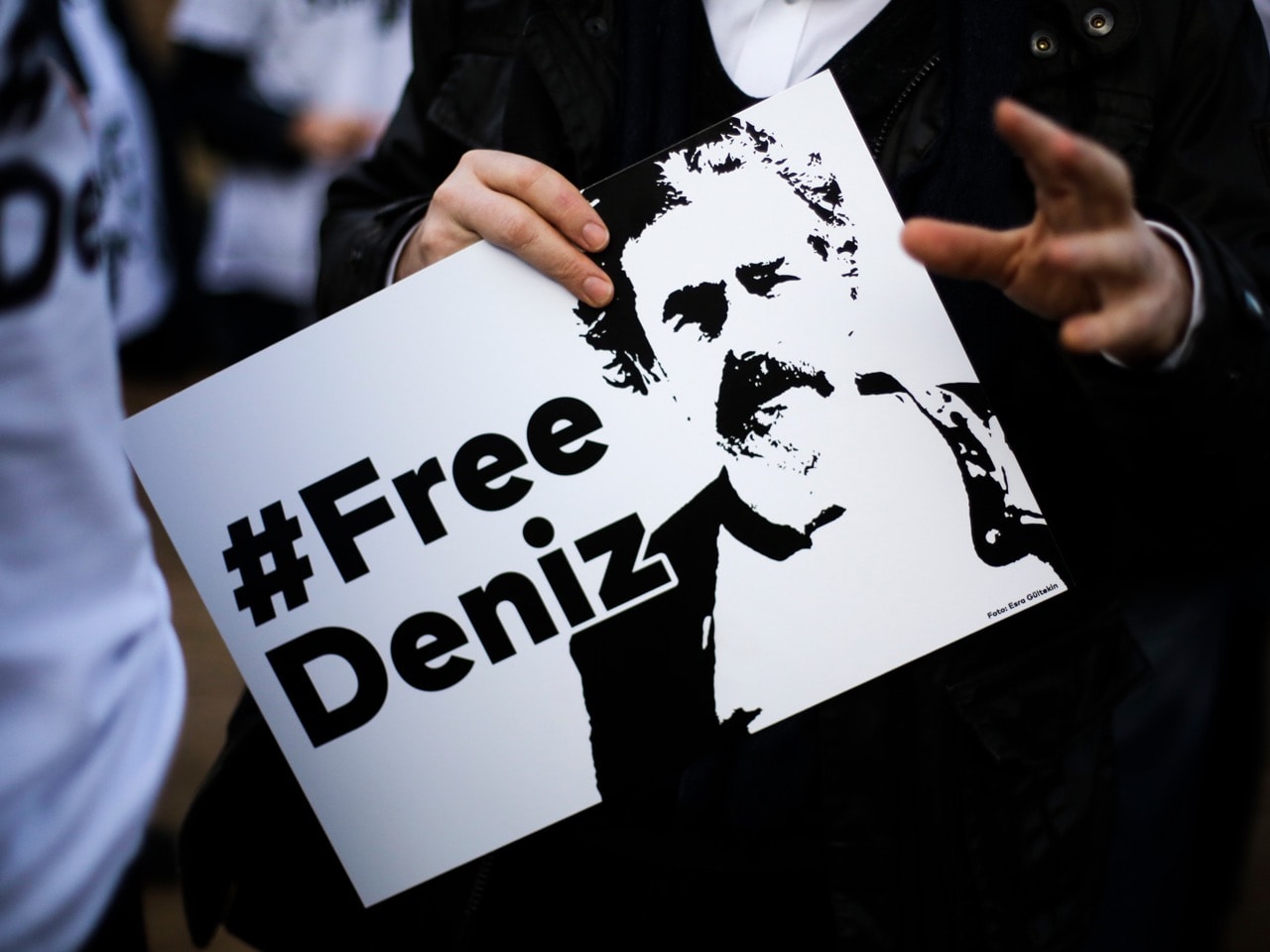 A man holds a poster with the slogan '#FREEDENIZ' during a protest in front of the Turkish embassy in Berlin, 28 February 2017, AP Photo/Markus Schreiber