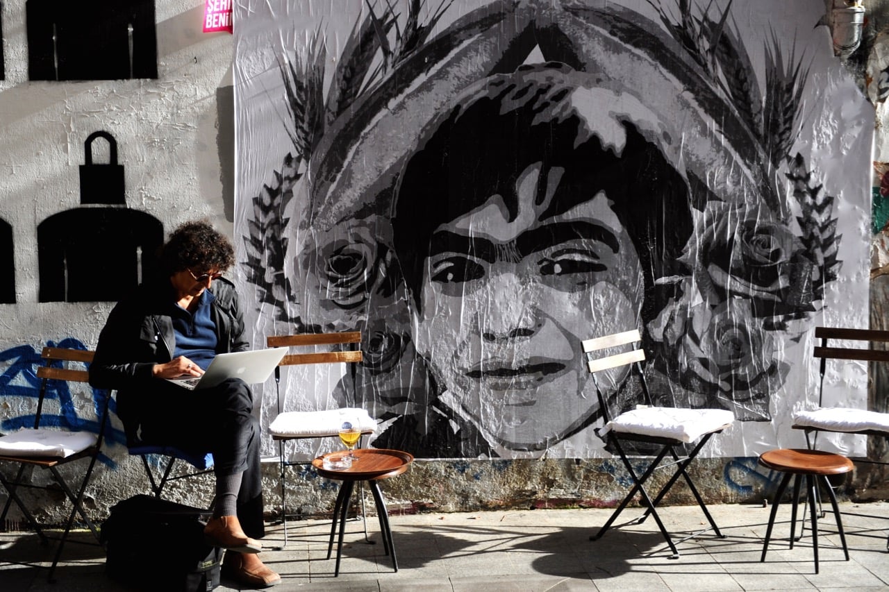 A man uses his laptop computer in Istanbul, Turkey, on 27 March 2014 as he sits next to a poster depicting a 15-year-old boy who died nine months after he was hit by a tear gas canister while going to buy bread during the 2013 protests in Istanbul, OZAN KOSE/AFP/Getty Images