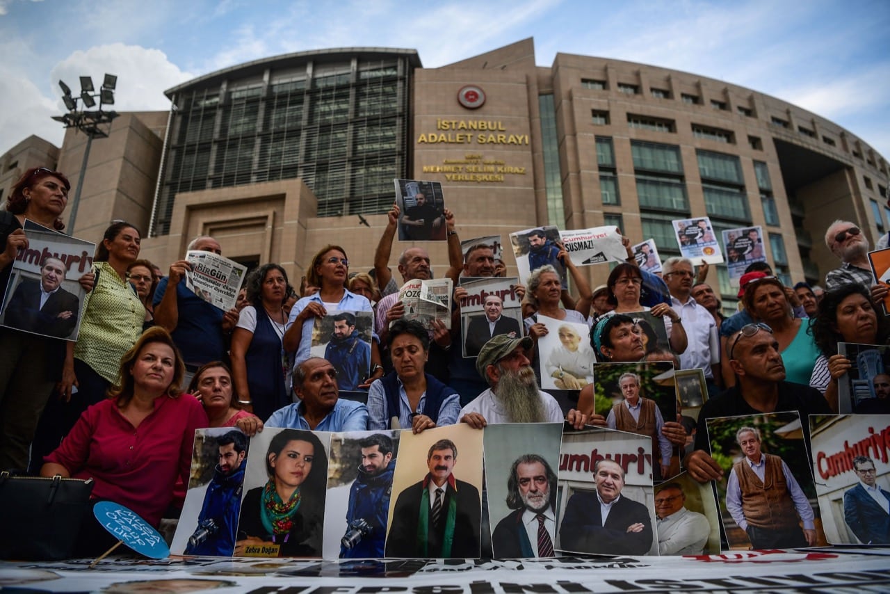 Protesters hold pictures of jailed "Cumhuriyet" journalists during a demonstration outside the courthouse in Istanbul, Turkey, 28 July 2017, OZAN KOSE/AFP/Getty Images