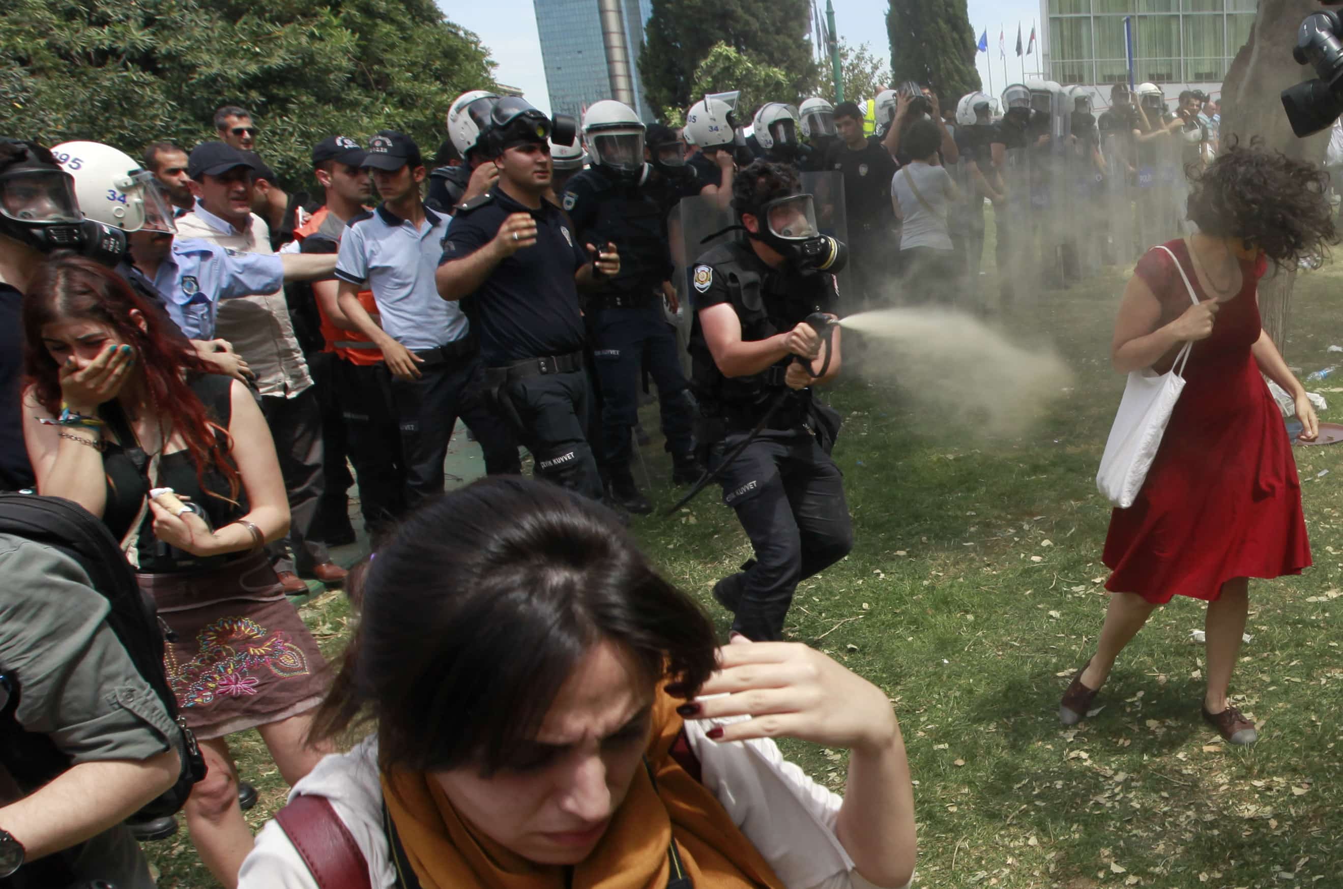 A Turkish riot policeman uses tear gas against a woman as people protest in Taksim Square, Istanbul, 28 May 2013, REUTERS/Osman Orsal