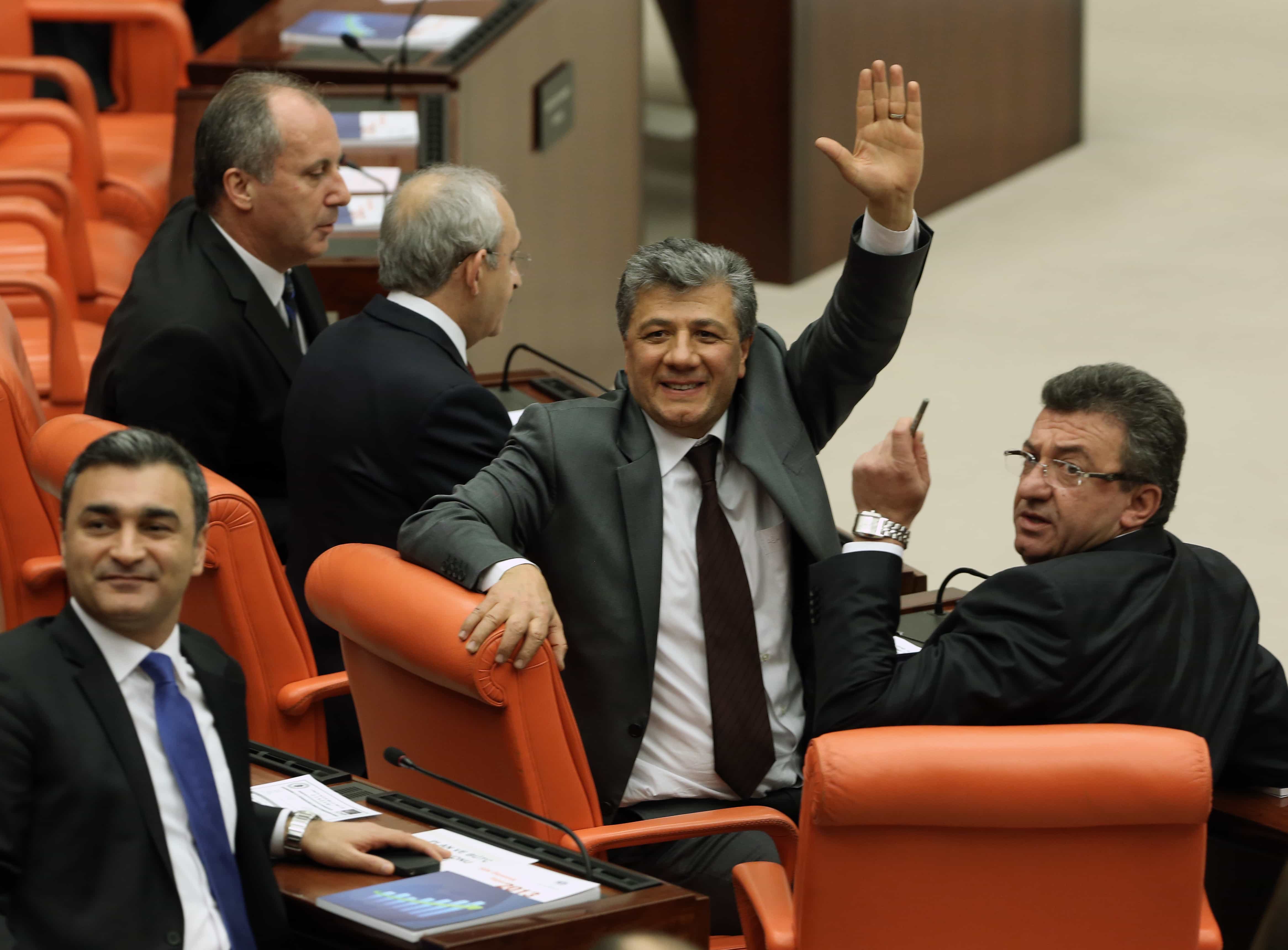 Mustafa Balbay salutes as he arrives to take his office oath in Parliament after spending nearly five years in jail, in Ankara, 10 December 2013., AP Photo/Burhan Ozbilici