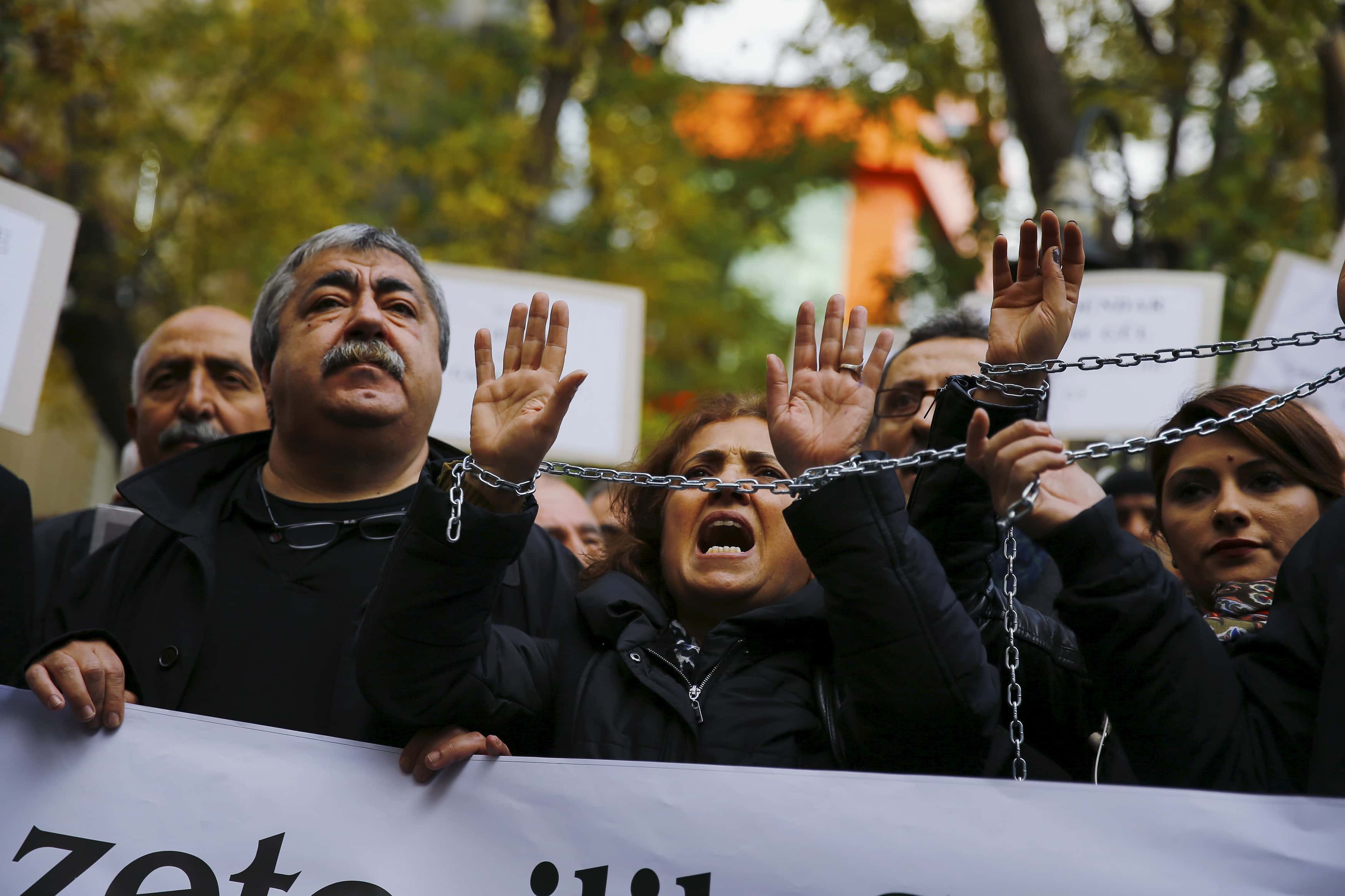 Demonstrators raise their chained hands during a protest over the arrest of journalists Can Dundar and Erdem Gul in Ankara, Turkey, 27 November 2015, REUTERS/Umit Bektas