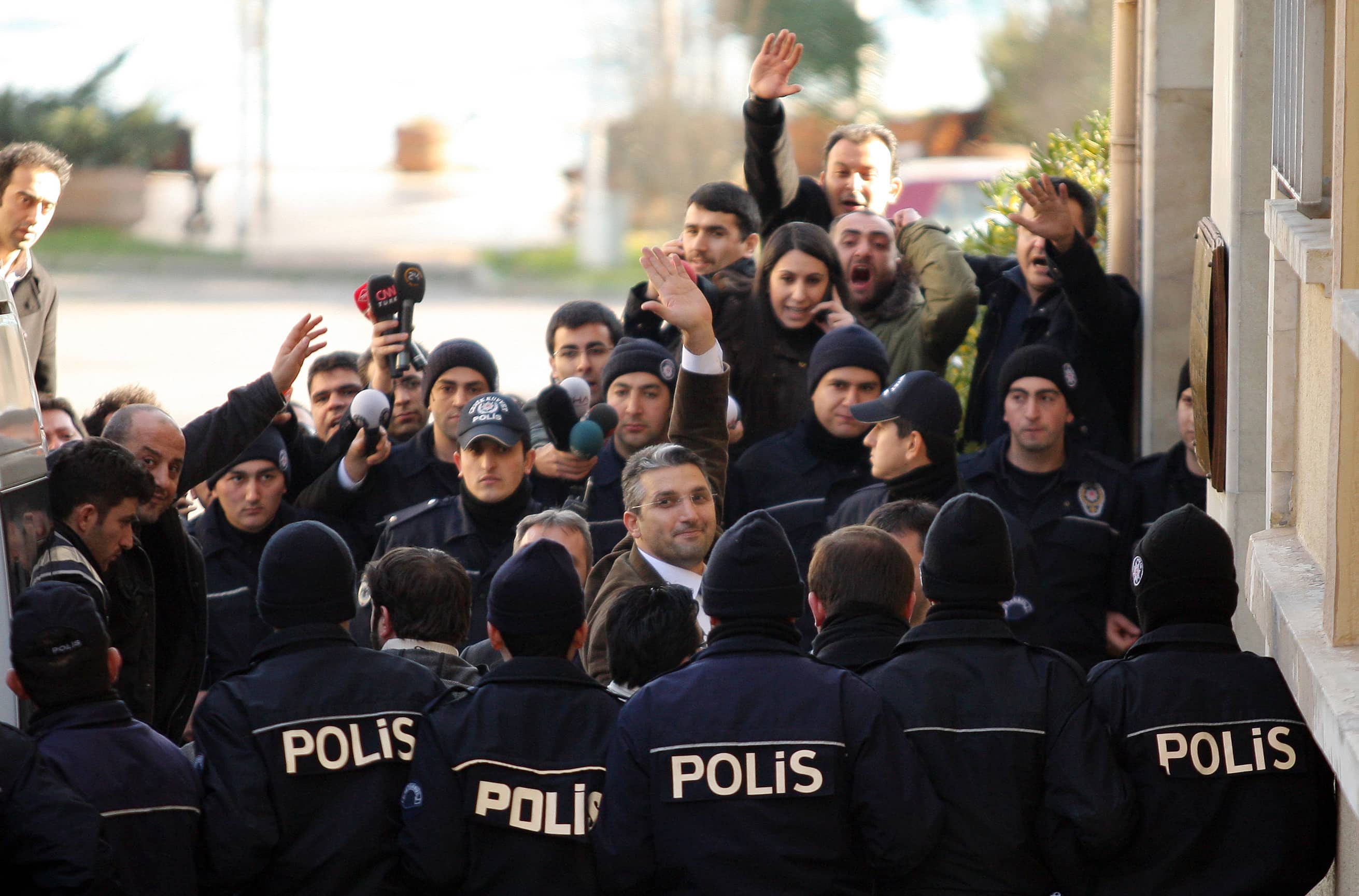 Journalists Nedim Sener (C) and Ahmet Sik (facing camera, 3rd L) wave upon arrival at a courthouse in Istanbul, 5 March 2011,  REUTERS/Ozan Guzelce/Milliyet/Handout