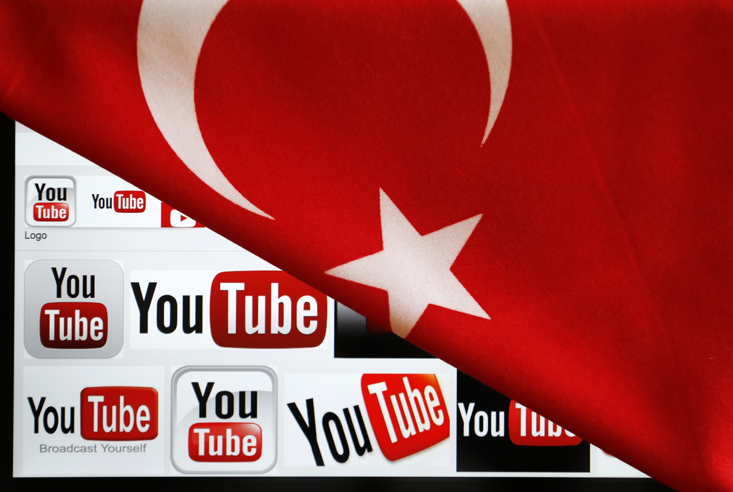 YouTube logos displayed on a laptop screen partially covered with Turkey's national flag in this photo illustration taken in Ankara, 27 March 2014, REUTERS/Umit Bektas