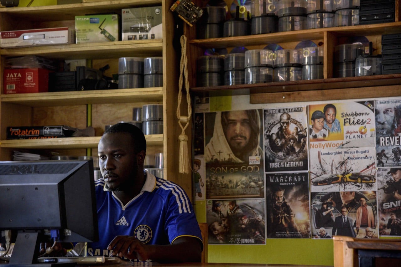 A Ugandan video library owner works on a computer in his shop in Soroti District about 300 kilometres northeast of the capital Kampala, 13 December 2016, ISAAC KASAMANI/AFP/Getty Images