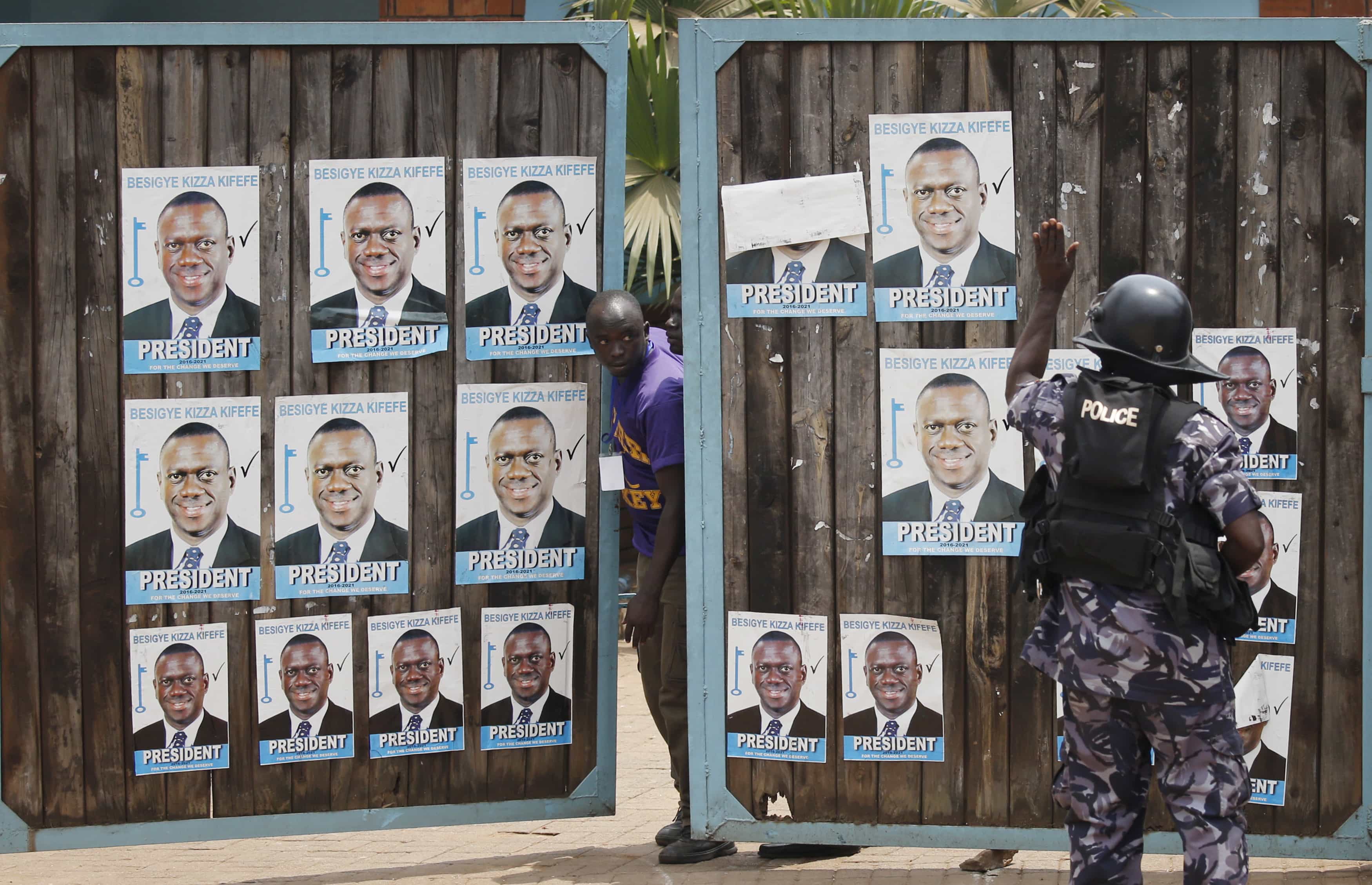 A supporter of opposition leader Kizza Besigye looks out from behind a gate of Besigye's office in Kampala, 19 February 2016, REUTERS/Goran Tomasevic